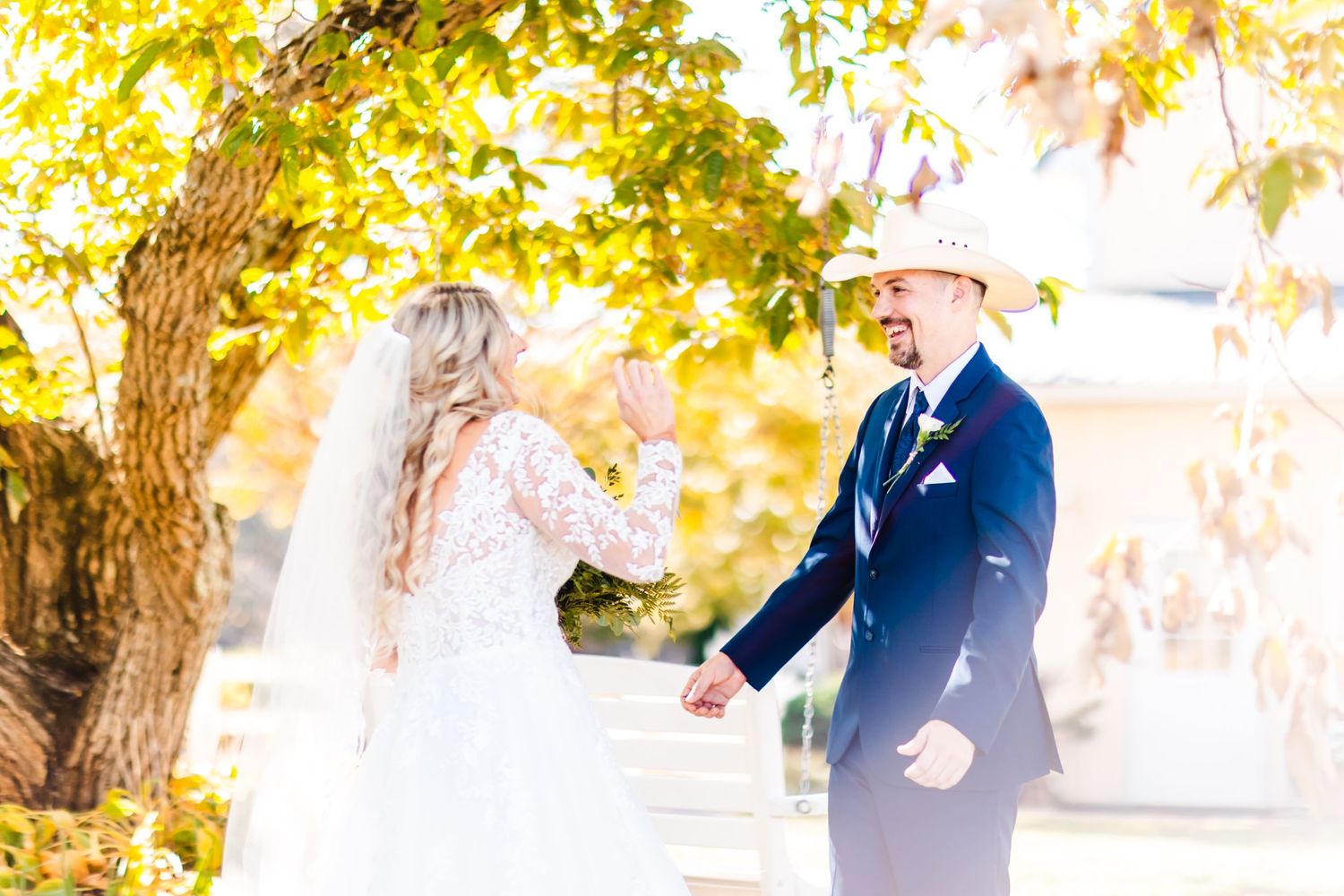 Couple shares first look moment under golden autumn trees.