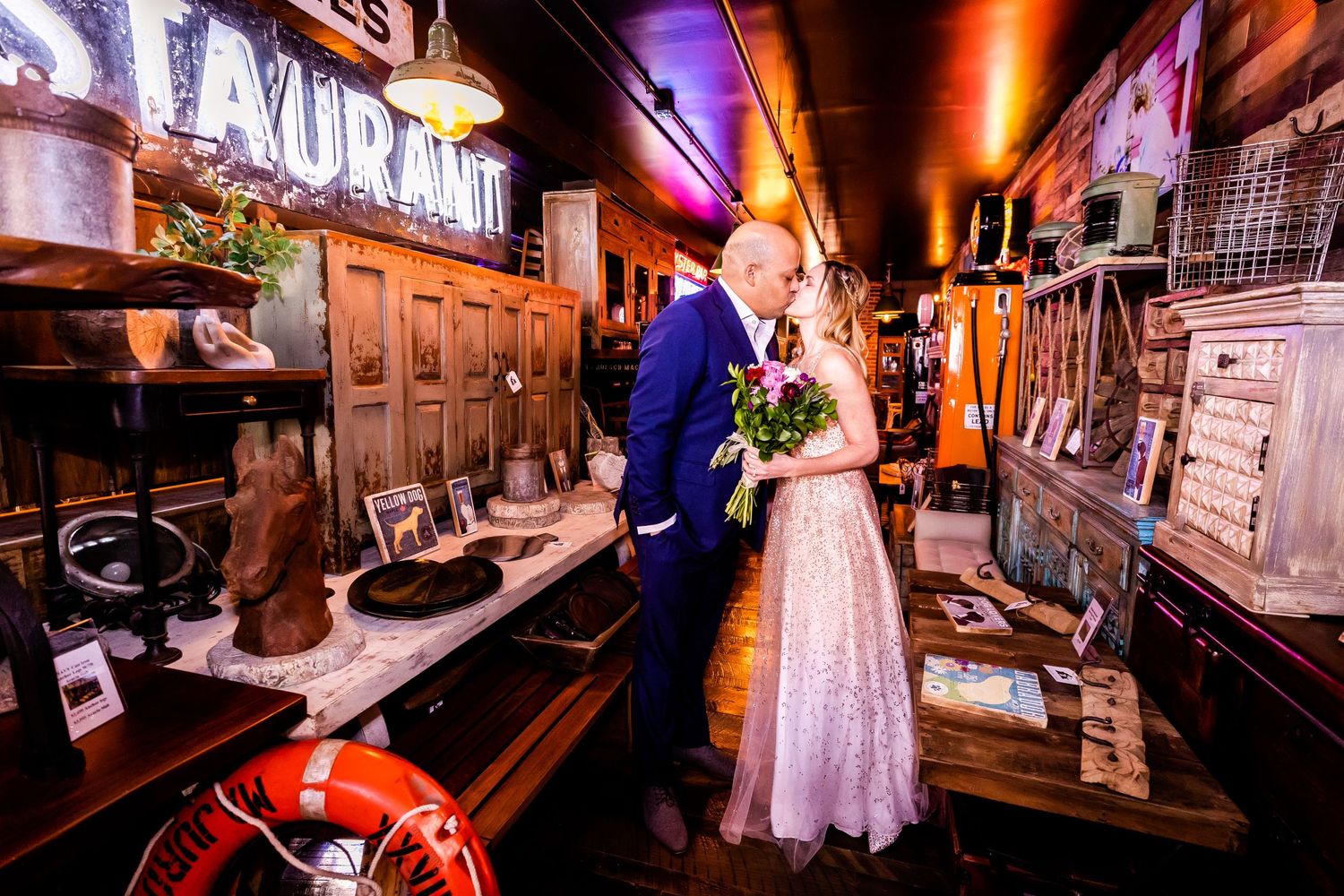 Newlyweds share a romantic moment in a vintage-styled bar with warm lighting.