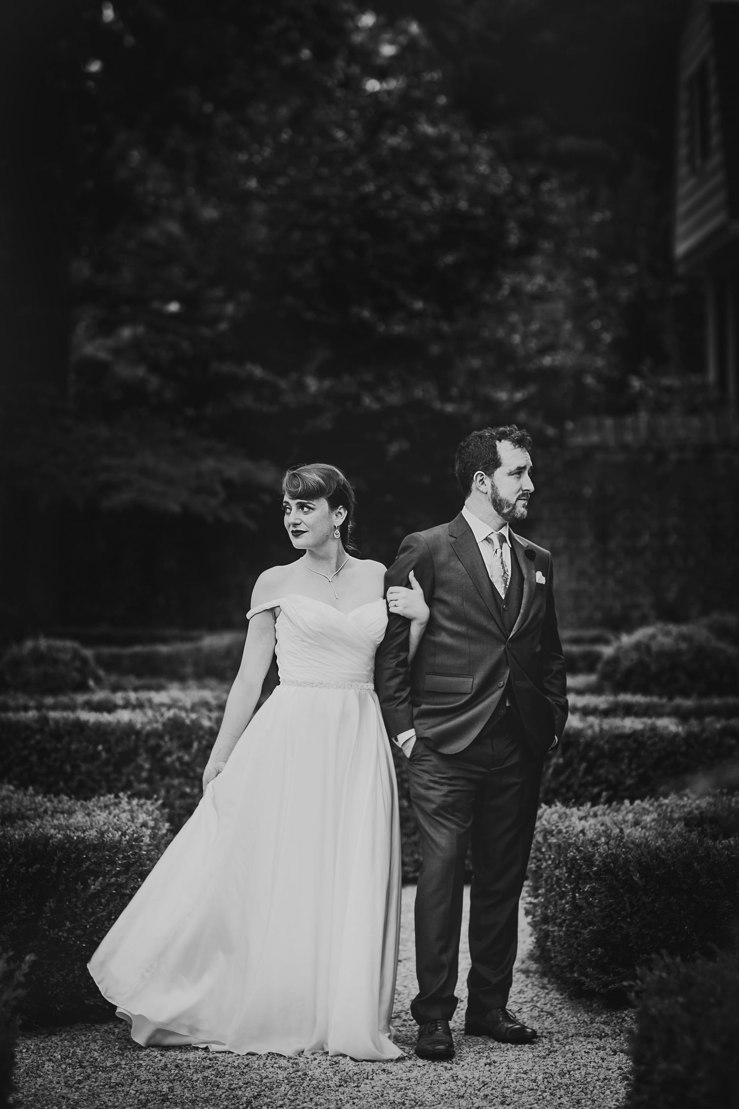 Classic black and white wedding portrait of couple walking together in formal attire.