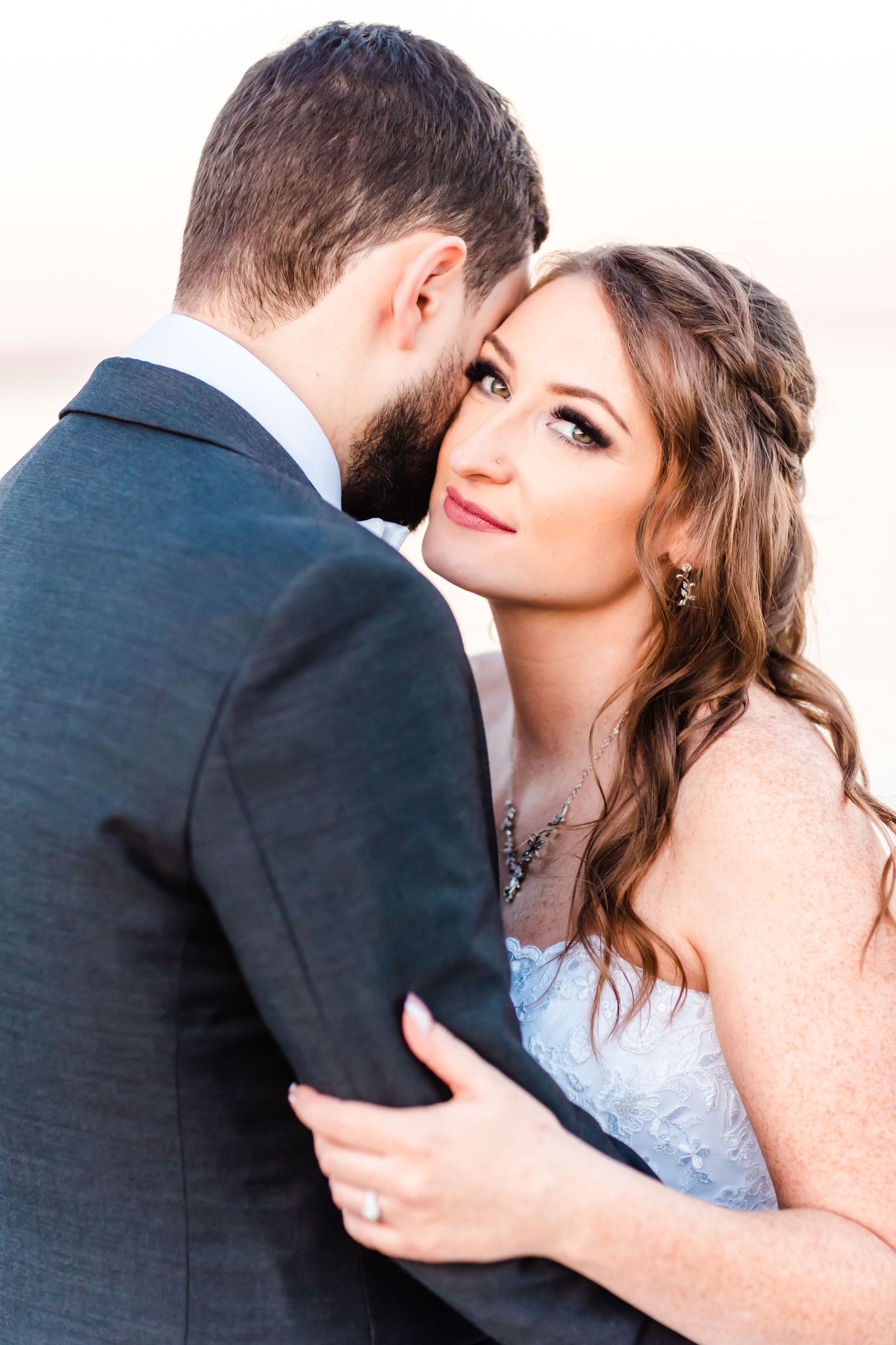 Intimate moment between newlyweds during sunset portrait session.