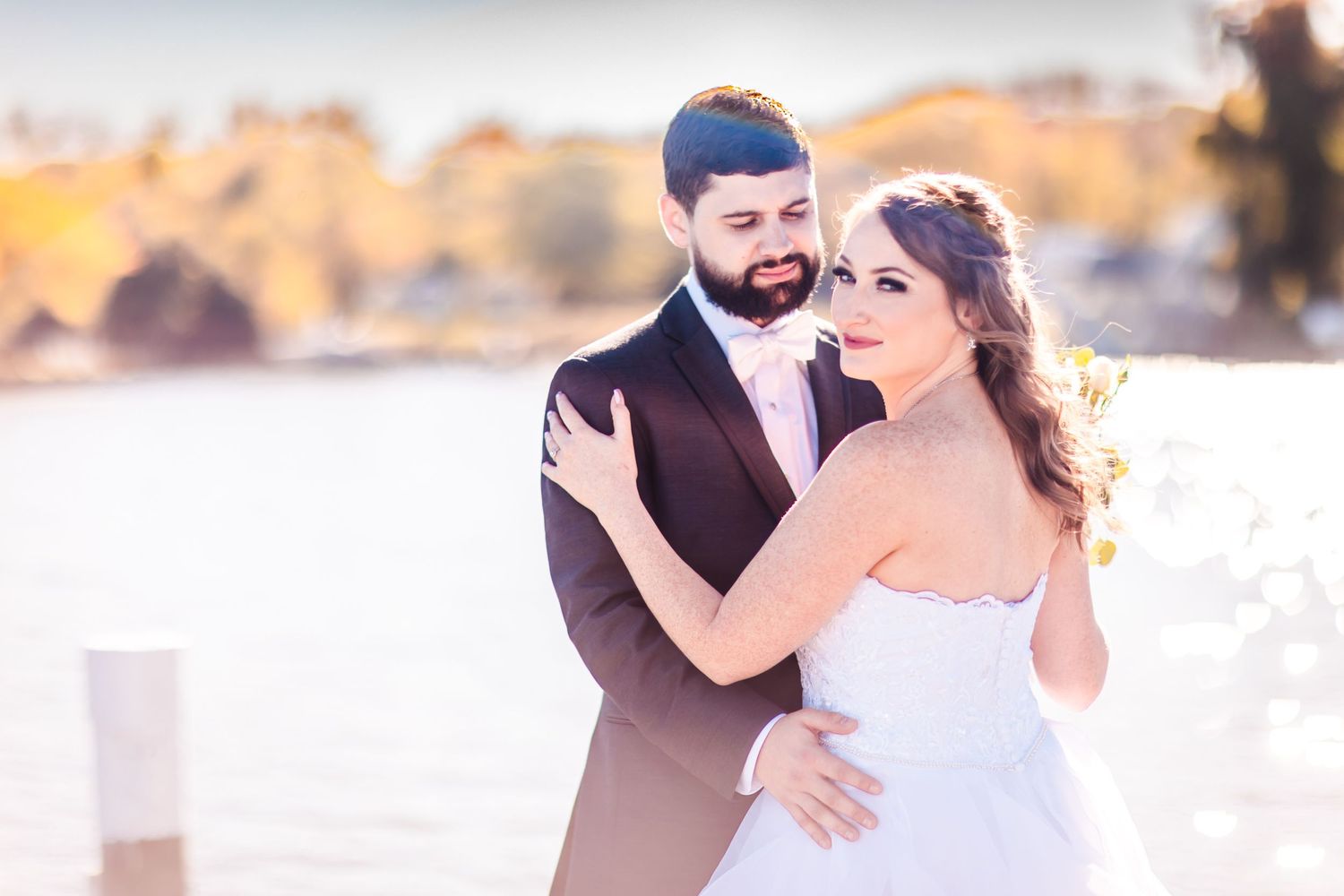 A romantic waterfront wedding portrait during golden hour.