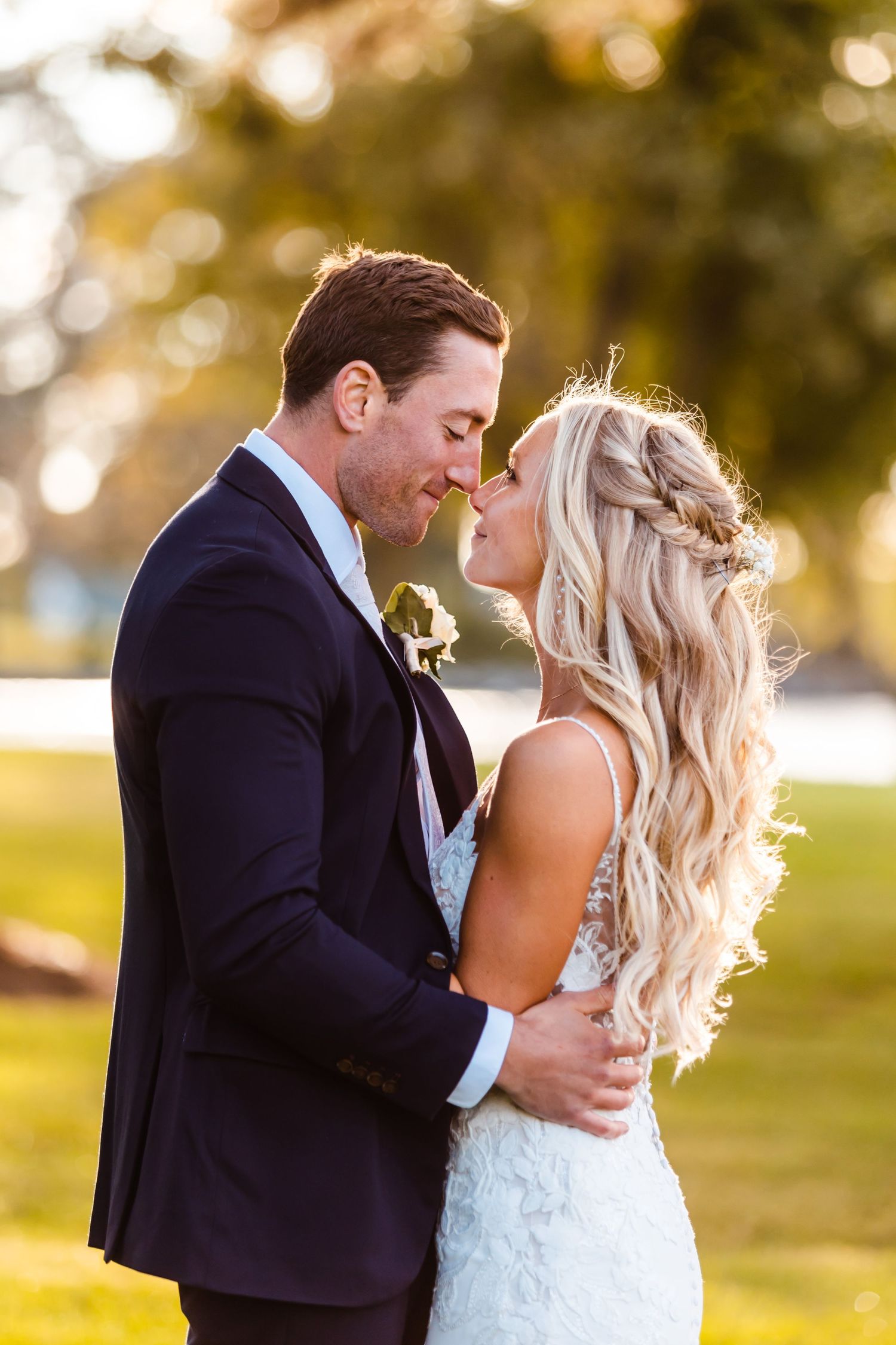 Romantic sunset portrait of newlyweds in intimate embrace outdoors.