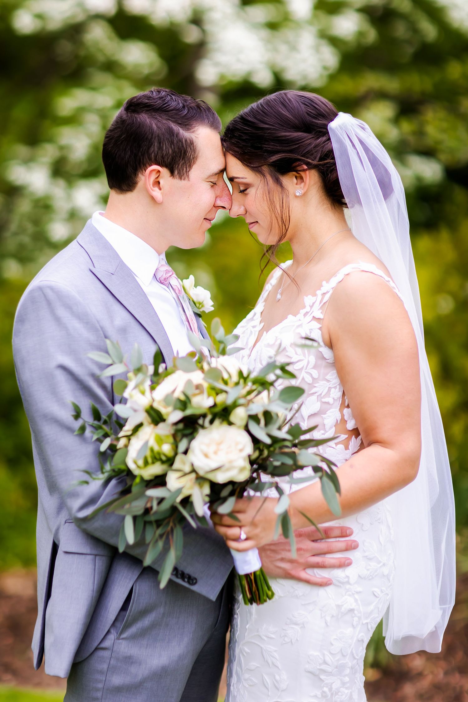 Intimate garden wedding portrait with white and green bouquet.