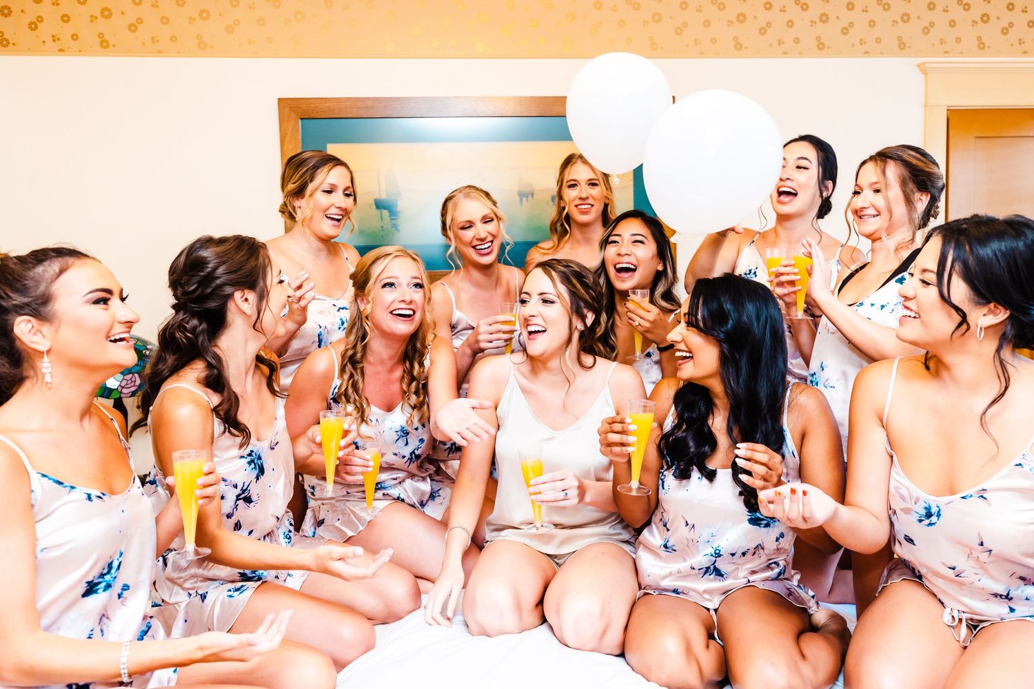 Group in floral robes shares celebratory moment together indoors.