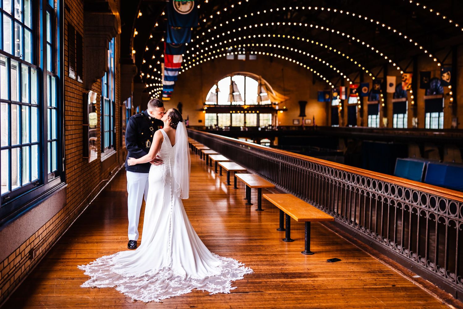 Romantic wedding photo in a vintage venue with string lights and wooden architecture.