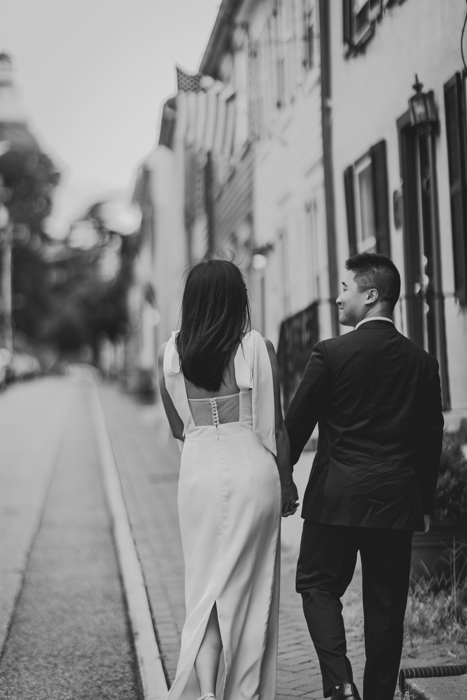 Black and white photo of couple walking down a charming narrow street.