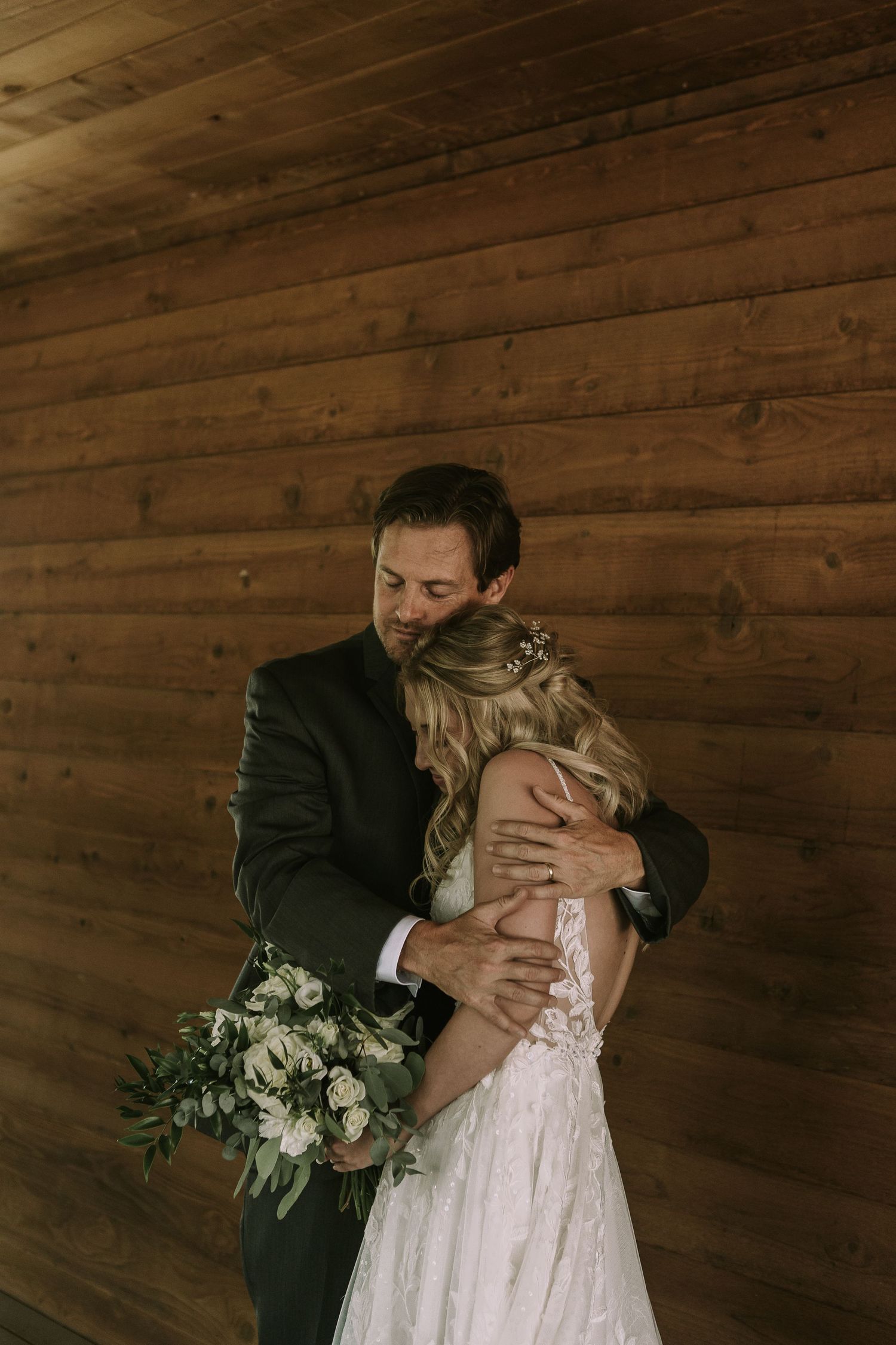 Intimate embrace against wooden barn wall background.