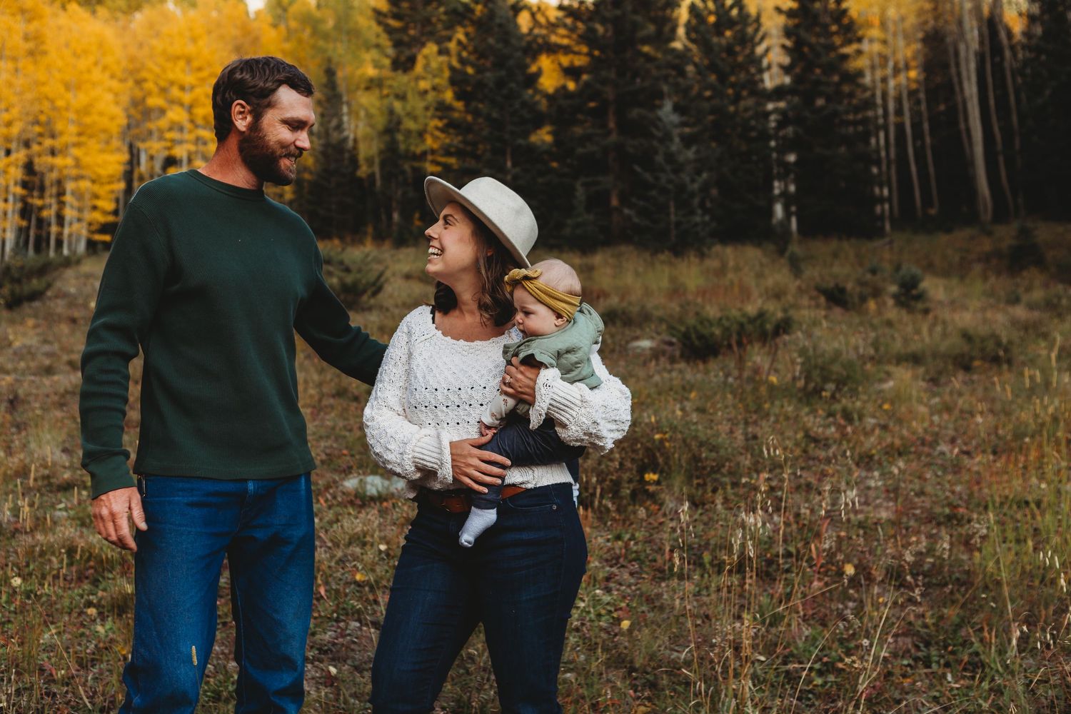Candid moment between people with golden aspen trees and mountains in the background.