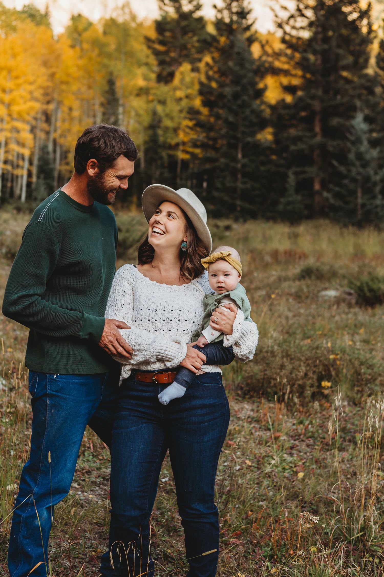 Candid family moment outdoors with fall foliage backdrop.