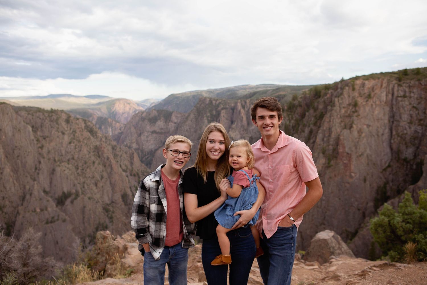 Family group poses at the edge of a dramatic canyon overlook.