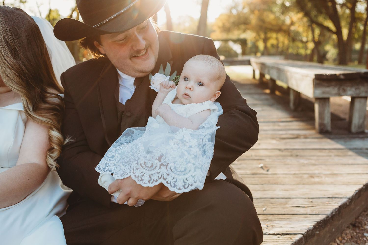A tender family moment shared on a wooden boardwalk during golden hour.