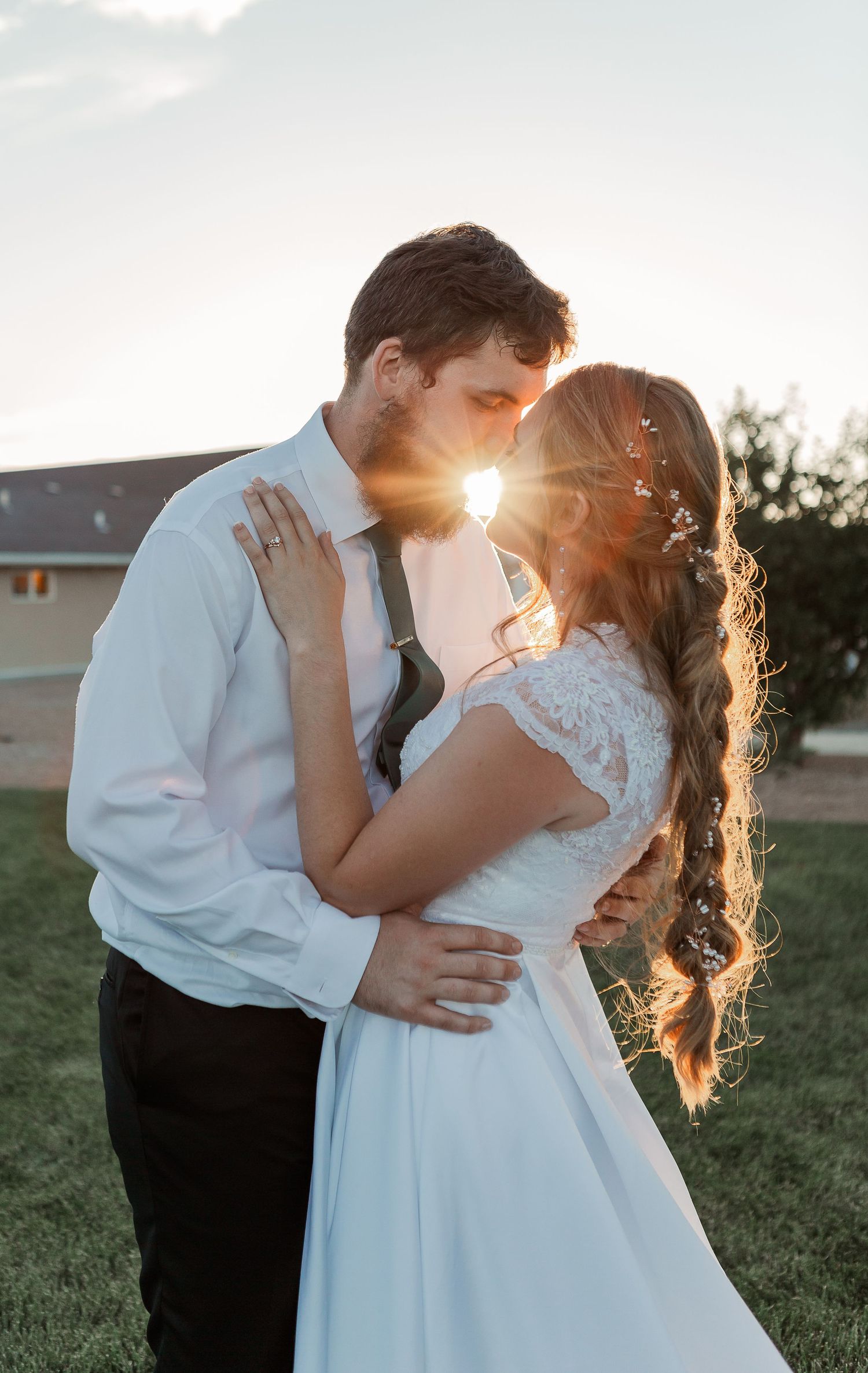 Romantic sunset wedding photo with a couple embracing in golden light.