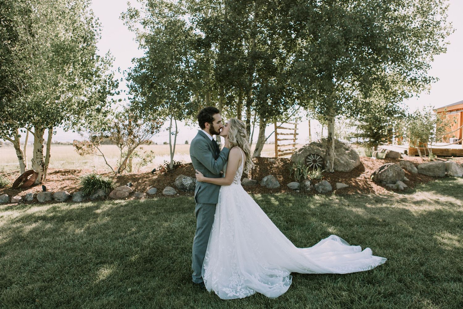 A full-length wedding portrait showing a beautiful white dress against a natural outdoor backdrop.