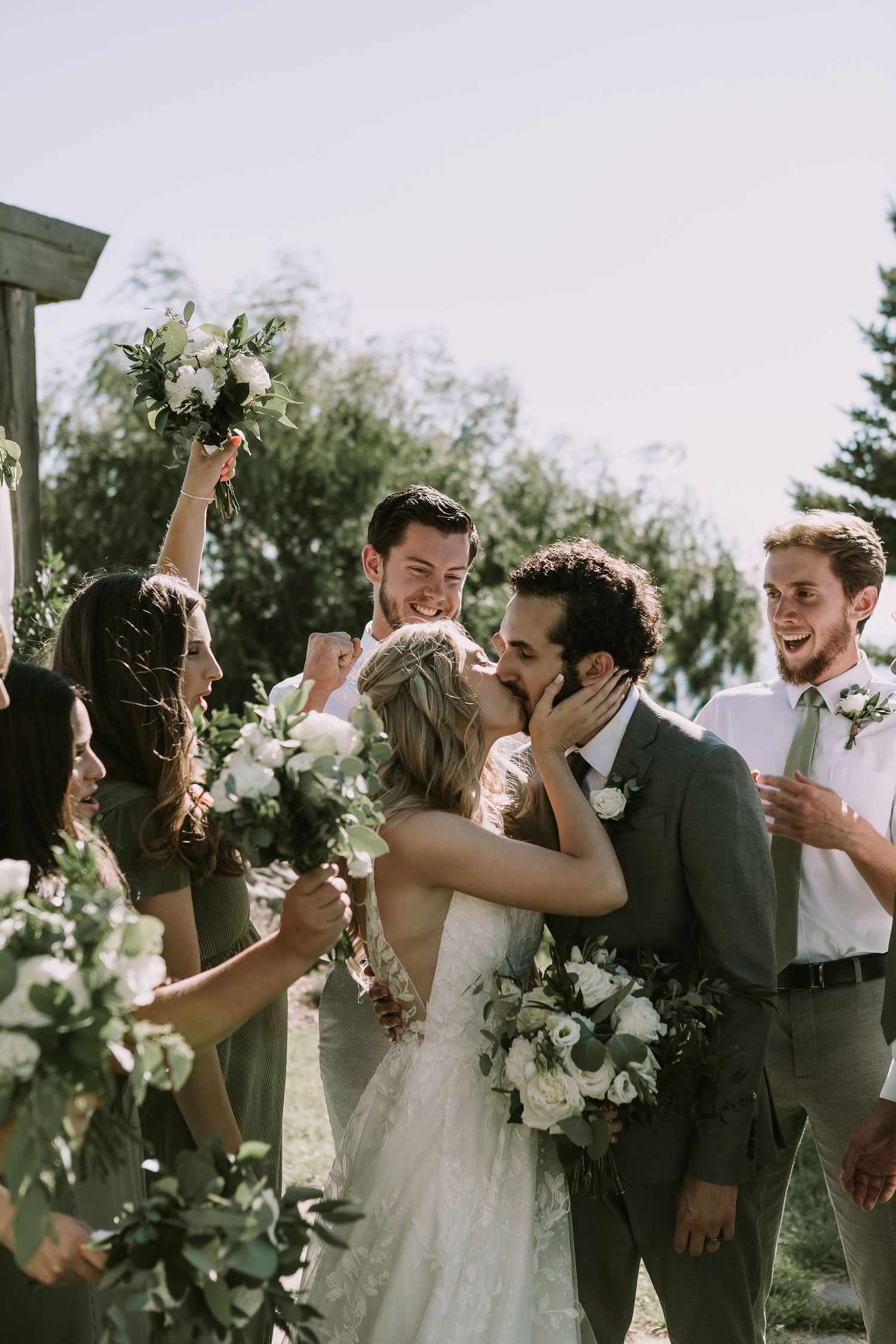 Wedding party celebrates with joy and laughter during outdoor ceremony.