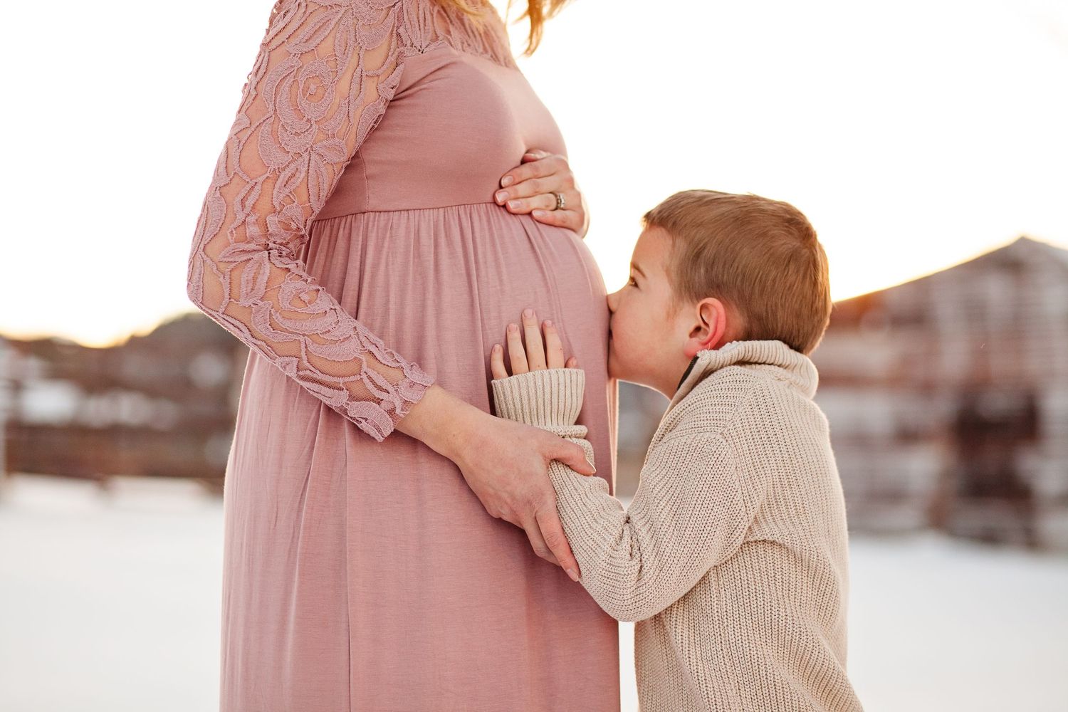 Intimate maternity moment captured in soft sunset lighting.