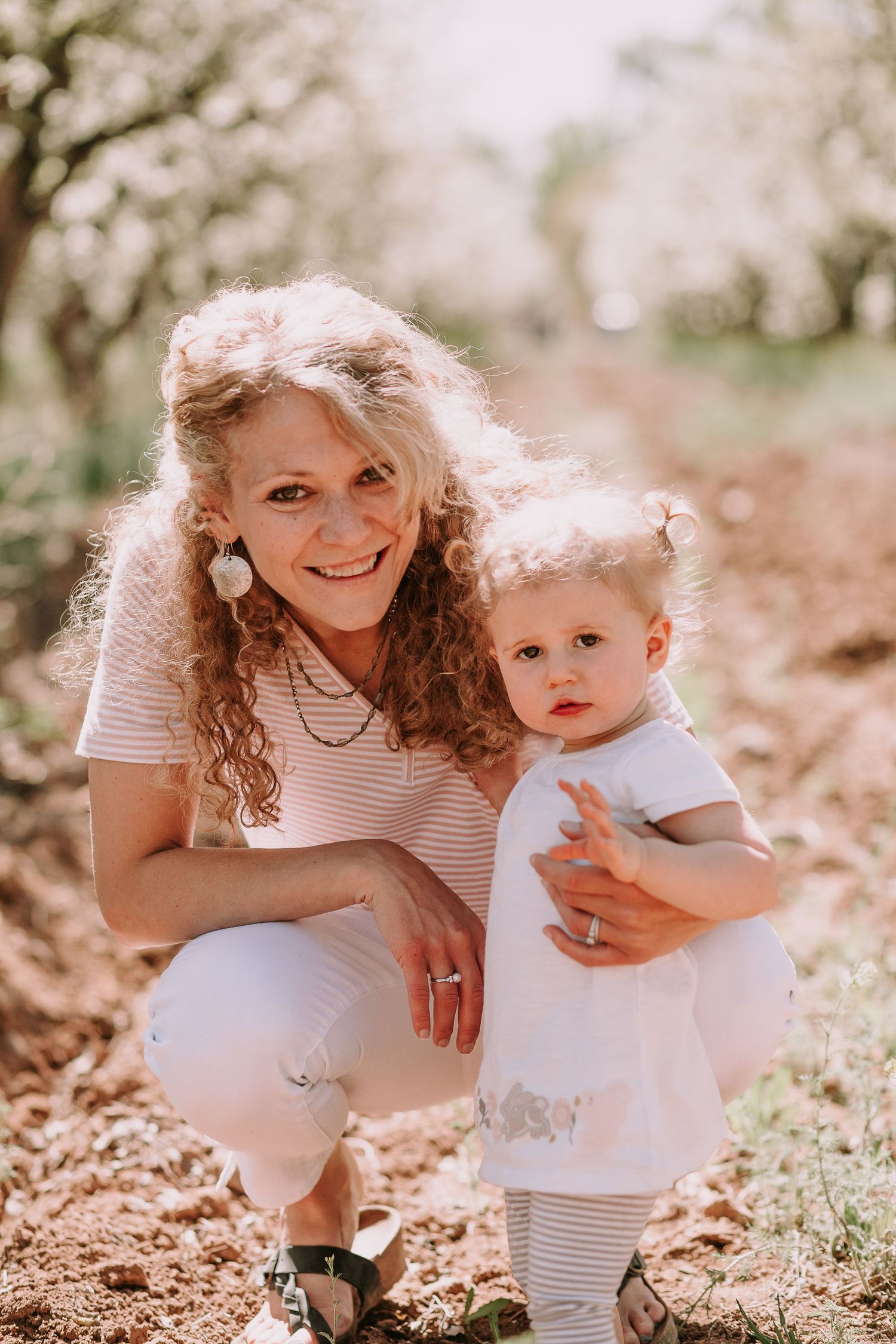 Springtime portrait in blooming orchard with white flowers and natural lighting.