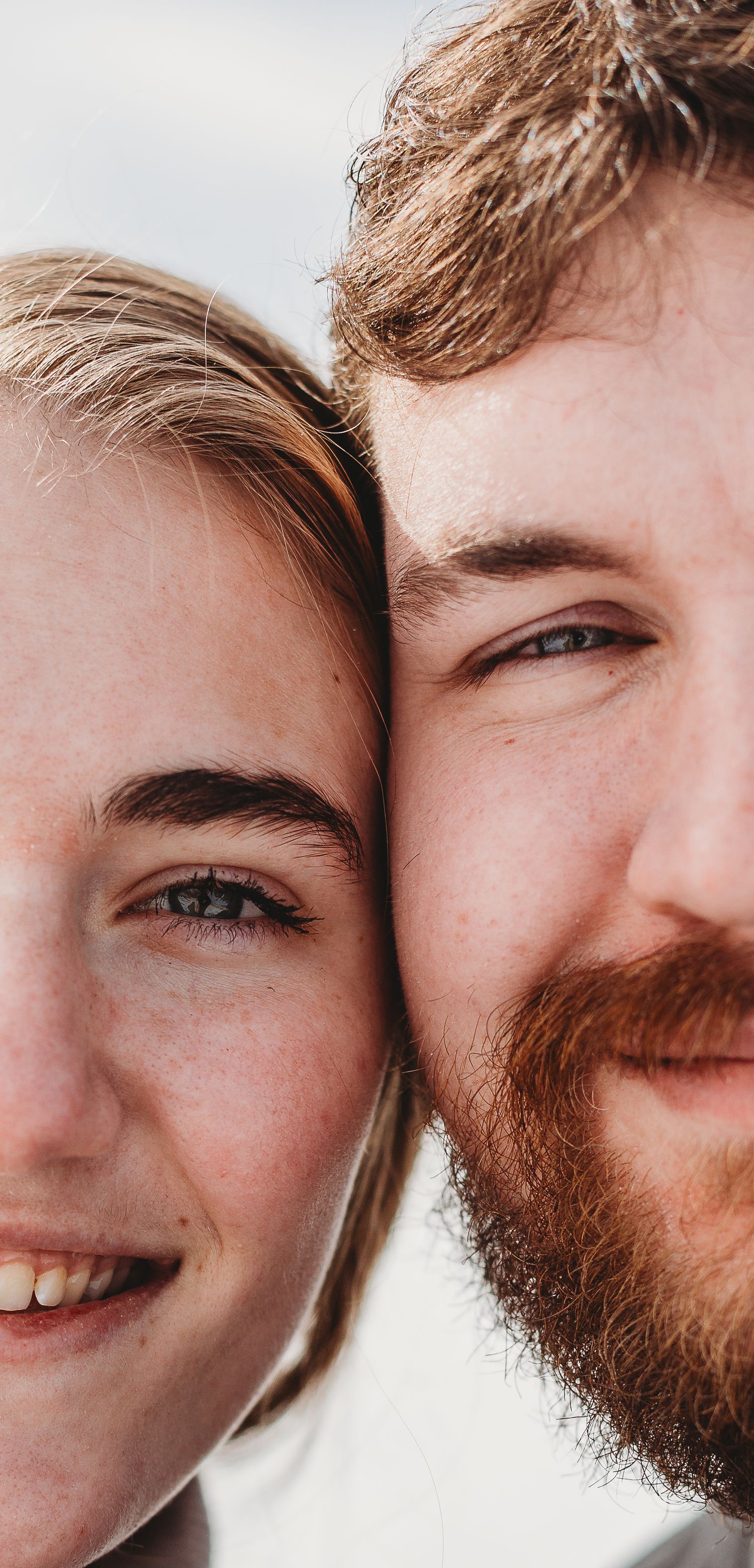 Close-up portrait of a couple's faces showing genuine joy and connection.