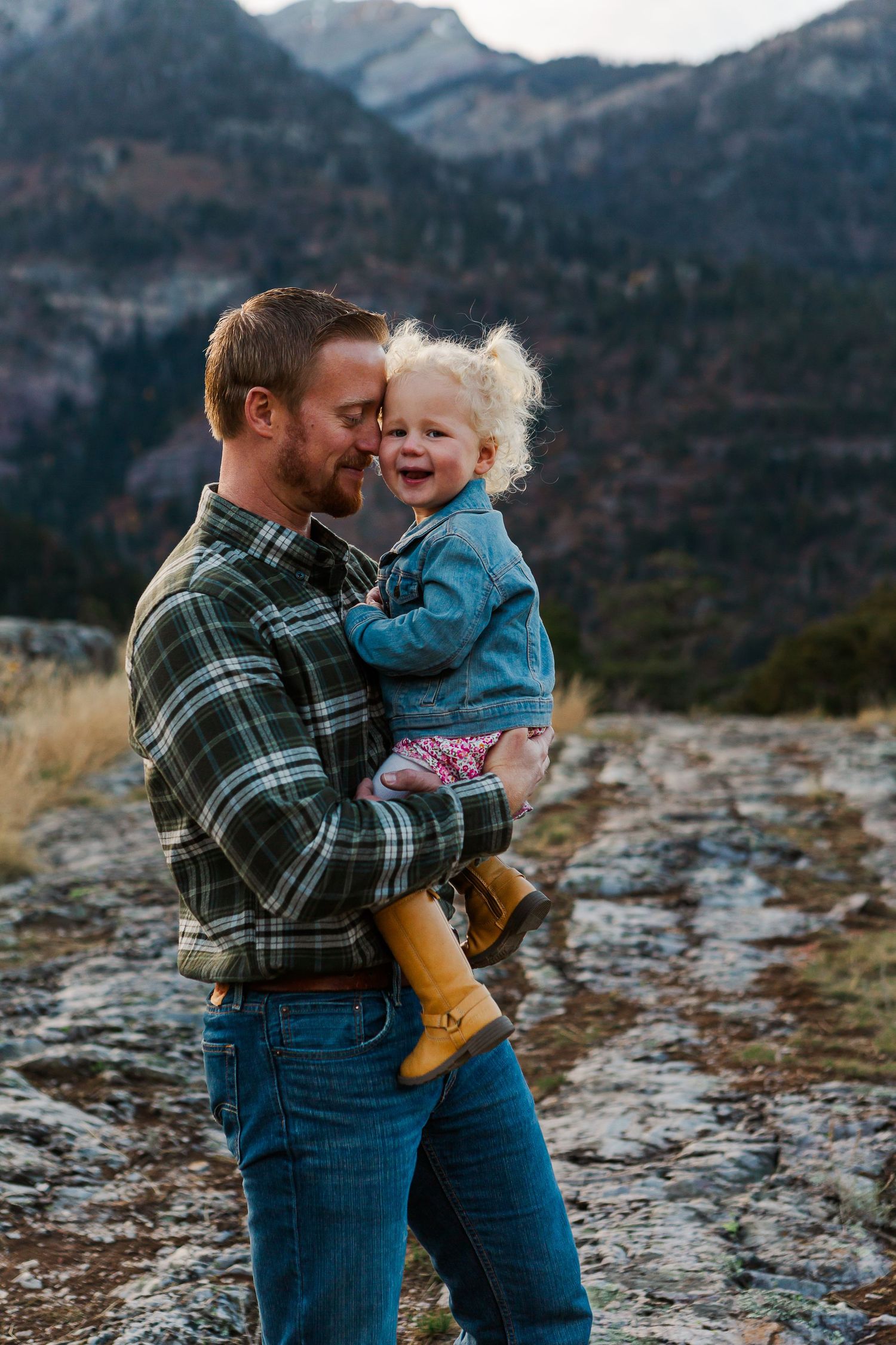 Intimate outdoor portrait captured with majestic mountain scenery and autumn colors in background.