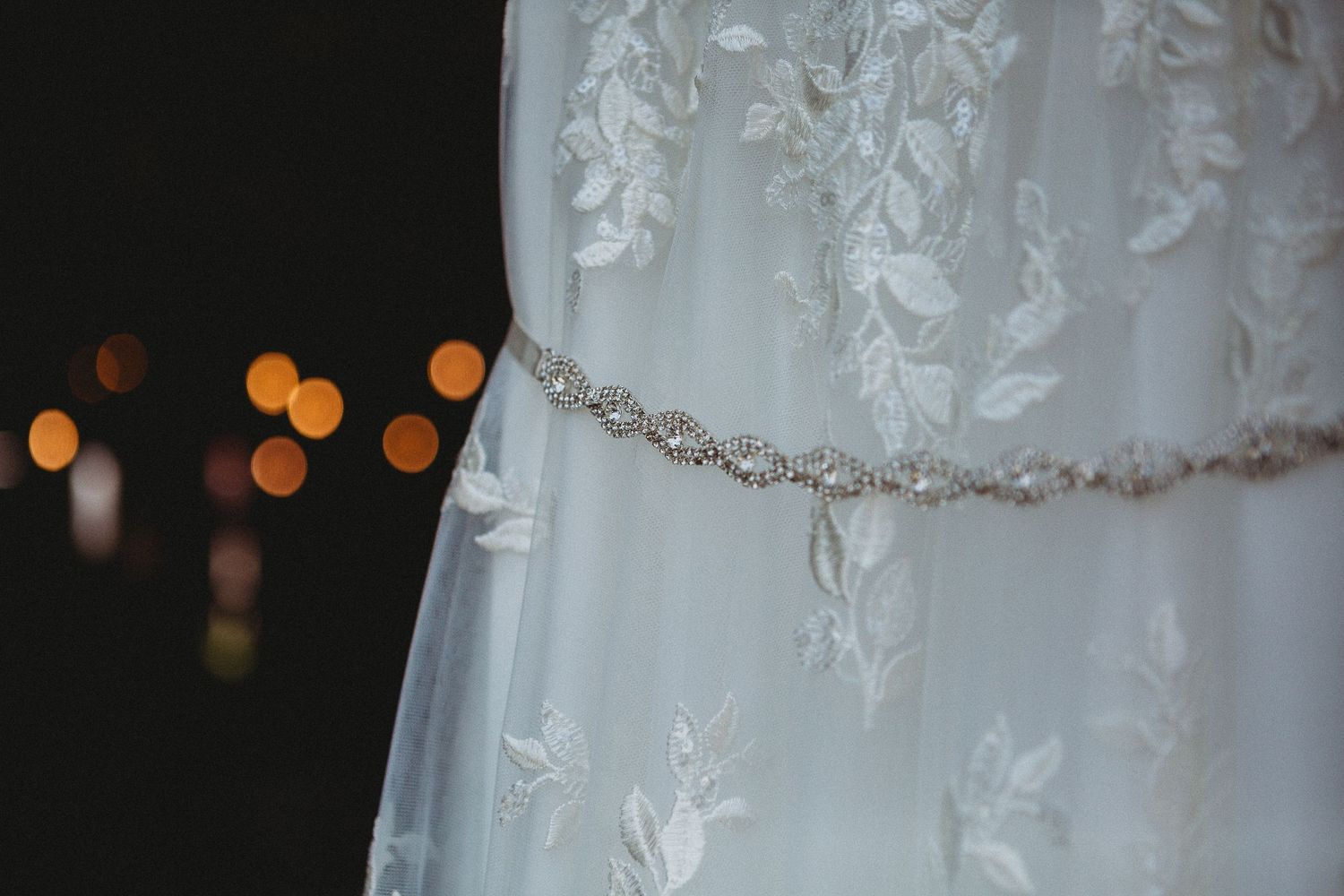 Delicate beaded details and floral embroidery on a white wedding dress fabric.