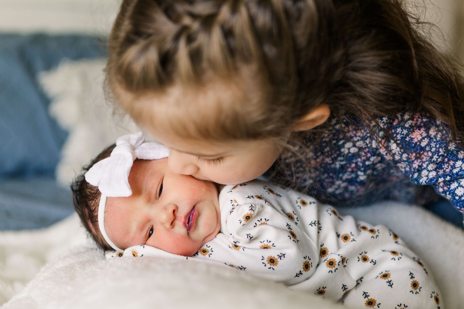 Close-up of siblings sharing an intimate moment during newborn photoshoot.