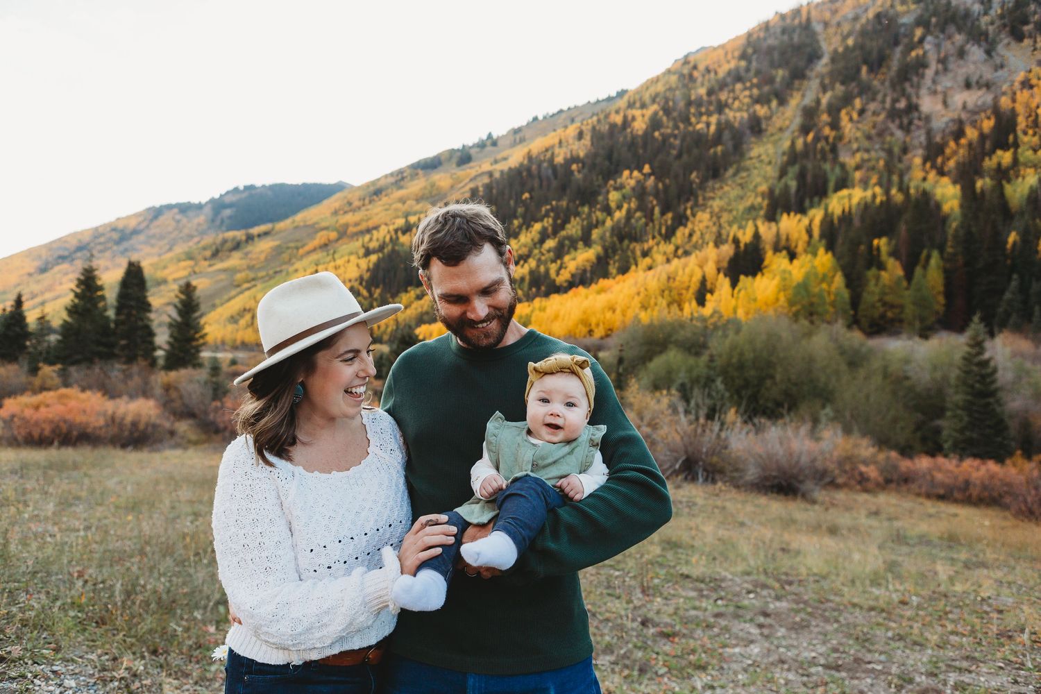 Family enjoying playful outdoor moment in scenic mountain valley.