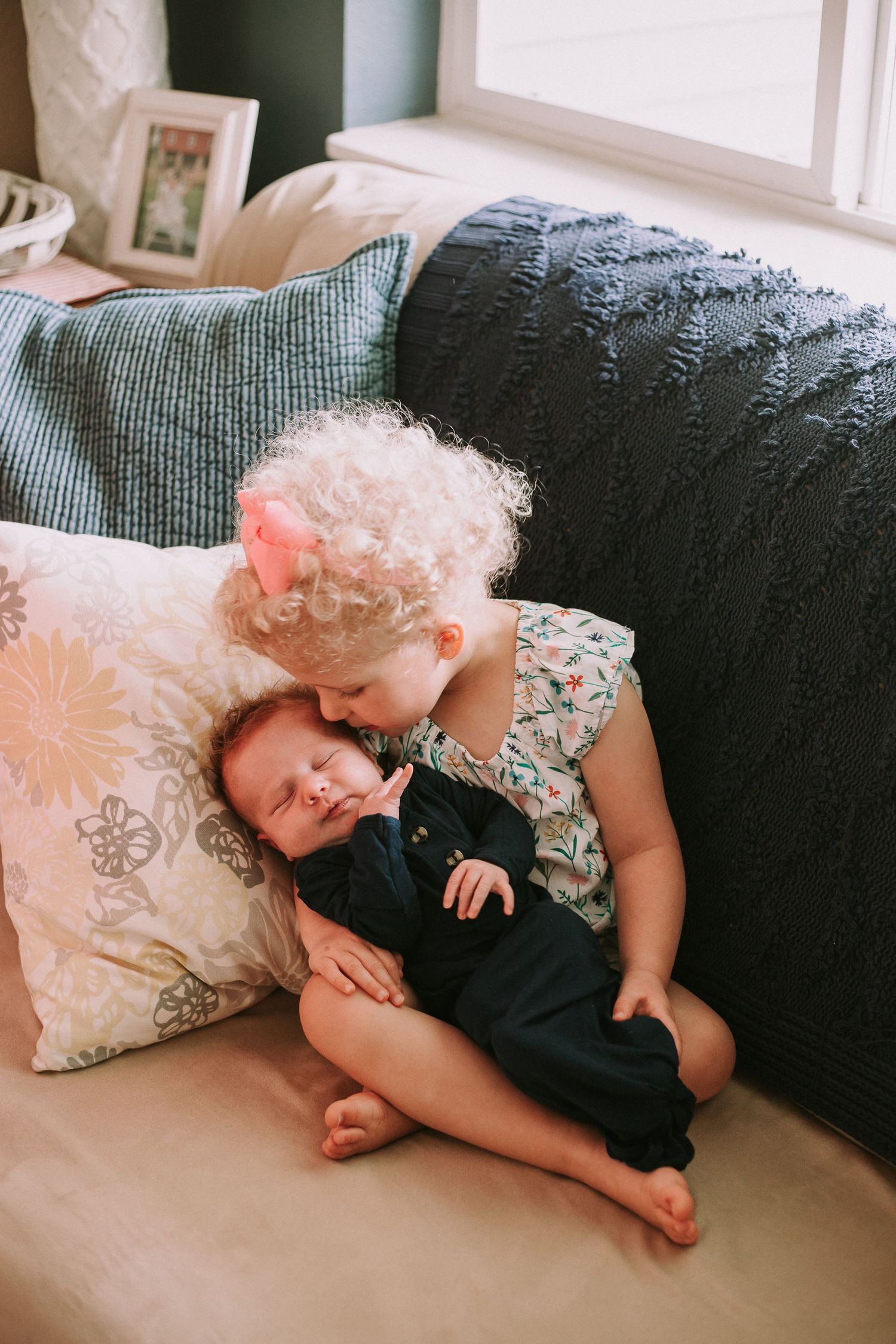 A tender moment shared between two people resting on a couch with pillows.