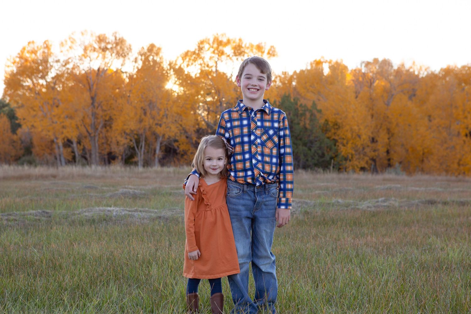 An autumn portrait captured at sunset with golden trees in the background.