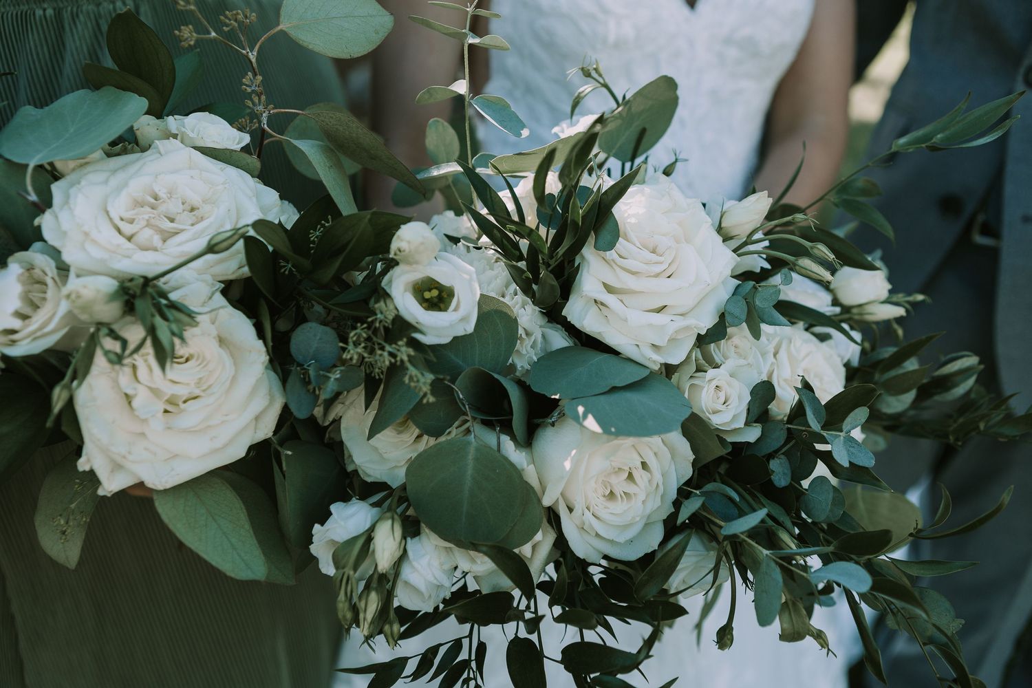 Close-up of white rose wedding bouquet with eucalyptus greenery.