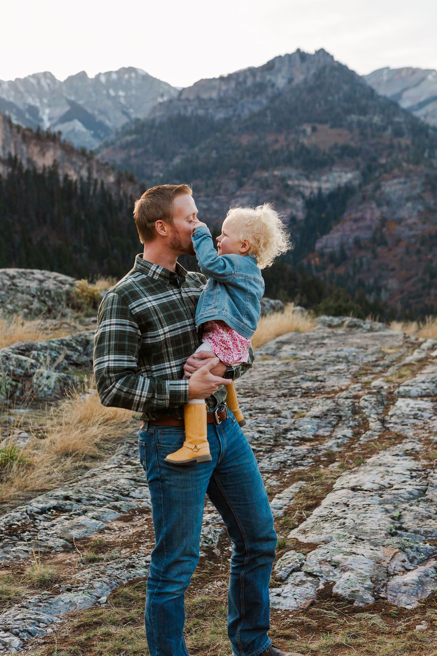 Tender outdoor moment photographed against scenic mountain backdrop during autumn.
