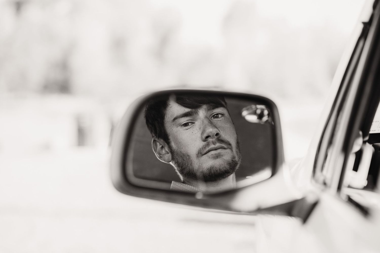 Artistic black and white reflection in side mirror of vehicle.