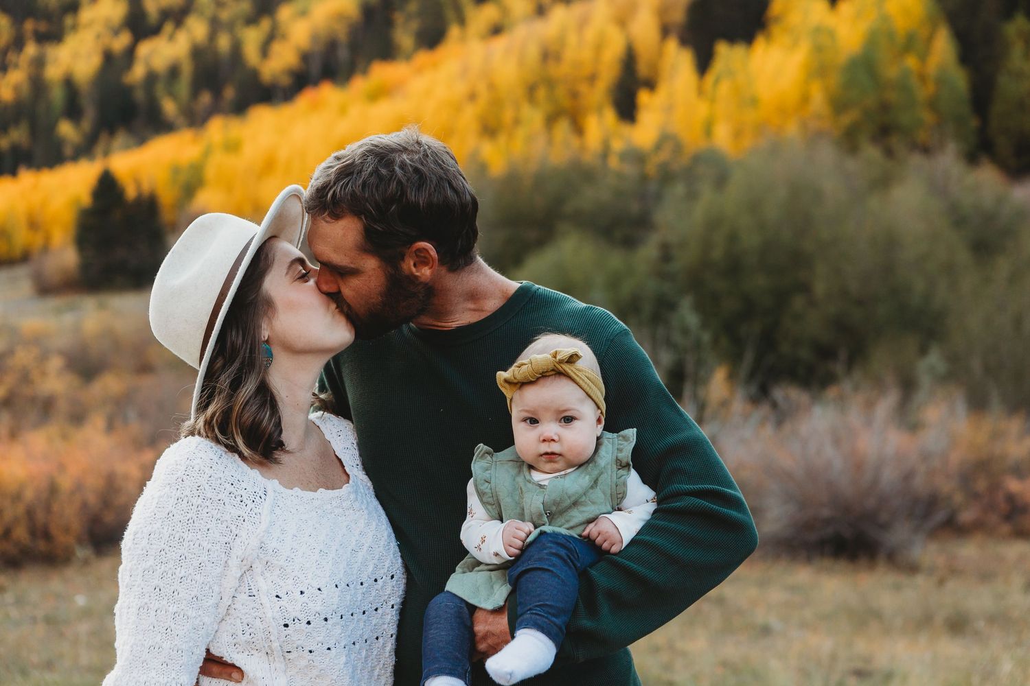 Tender family moment captured in mountain setting with fall colors.