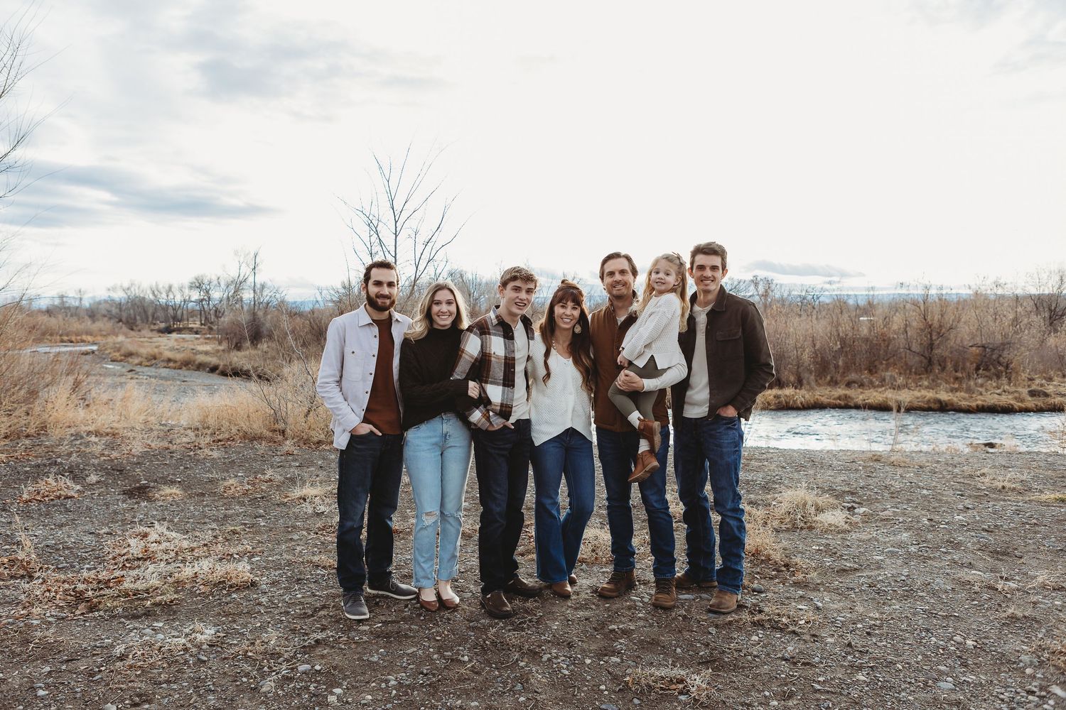 Group photo of family members posed together in a natural winter landscape.
