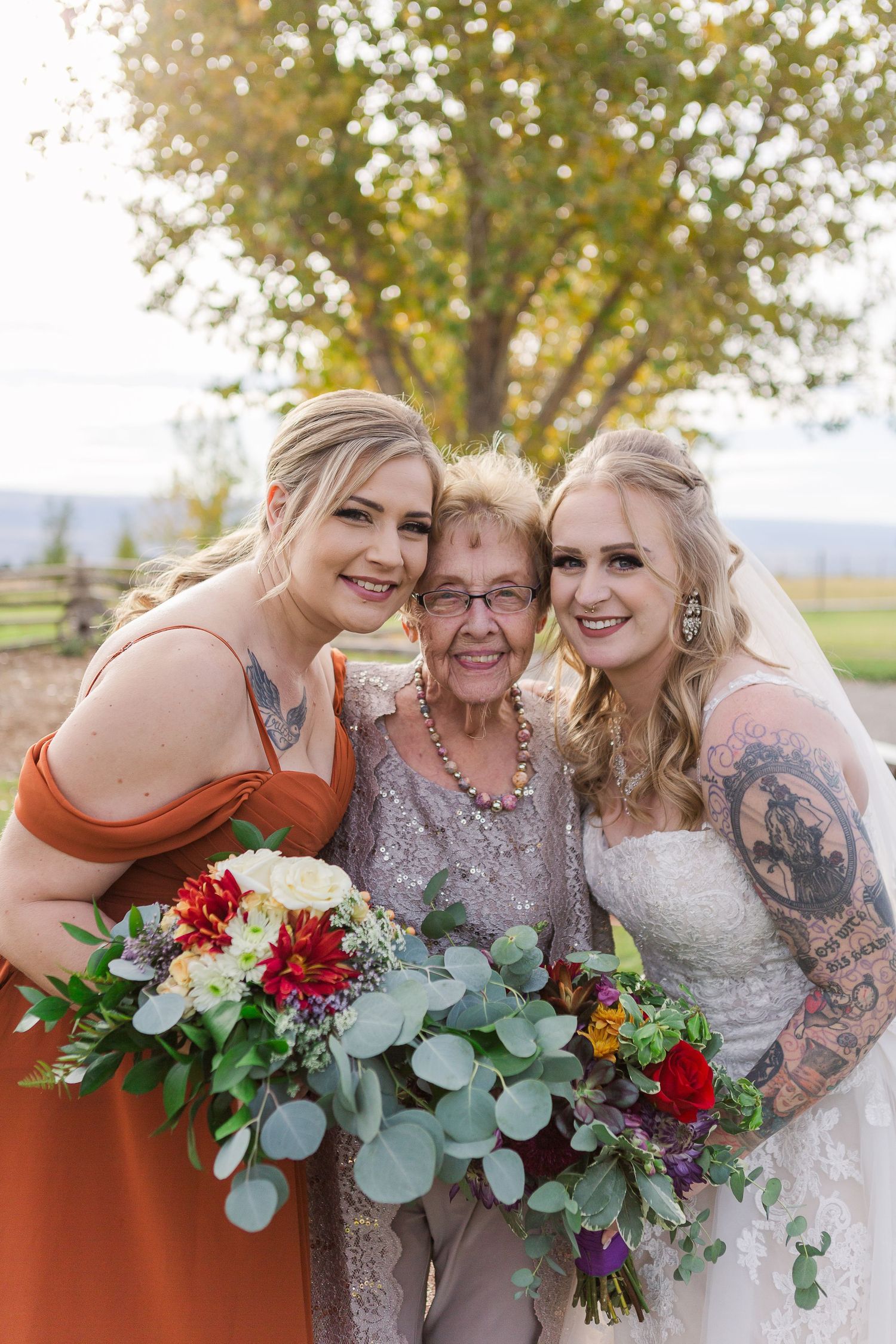 Three generations pose together with beautiful red and green wedding bouquets.