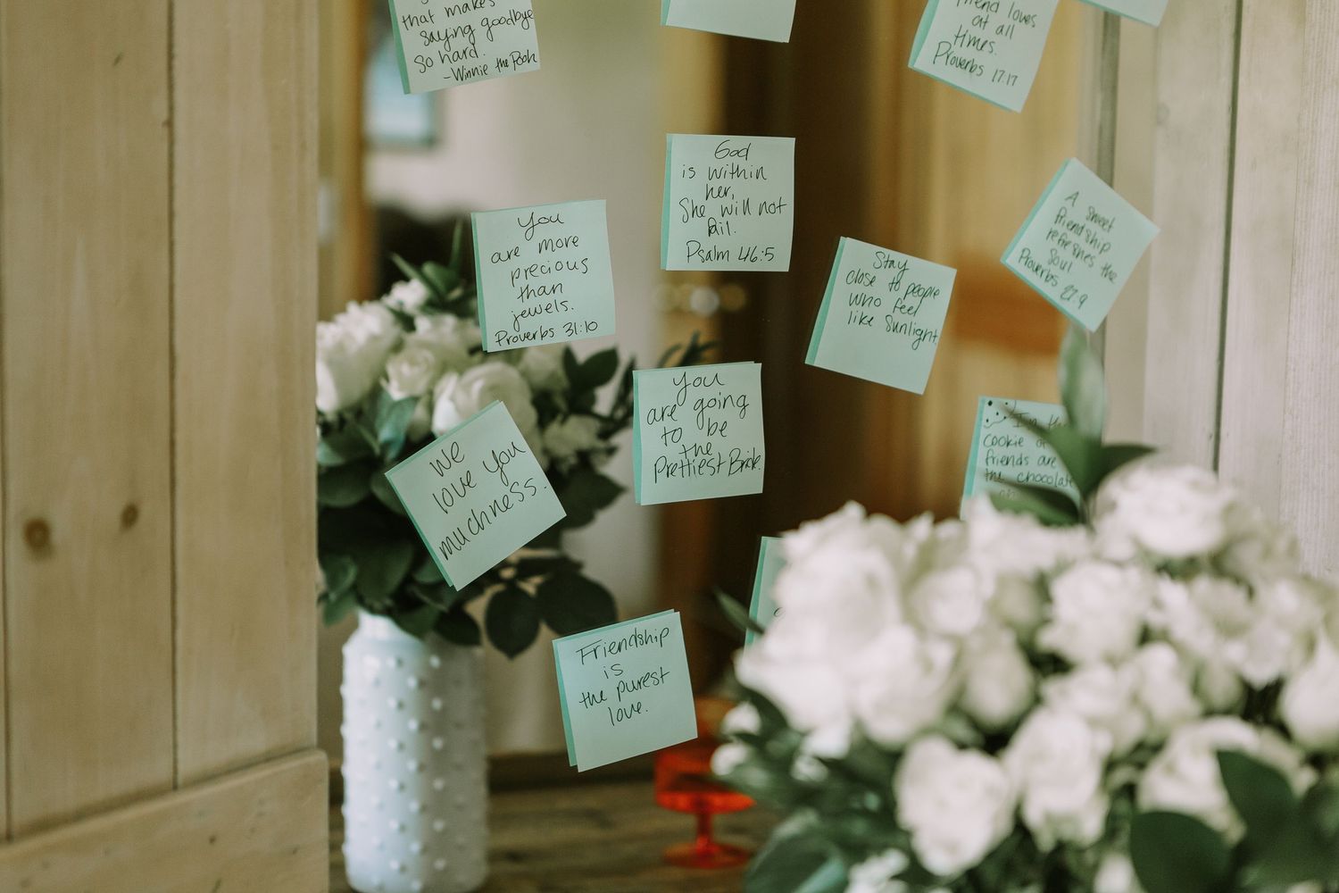 White floral arrangements with handwritten notes displayed against a wooden backdrop.