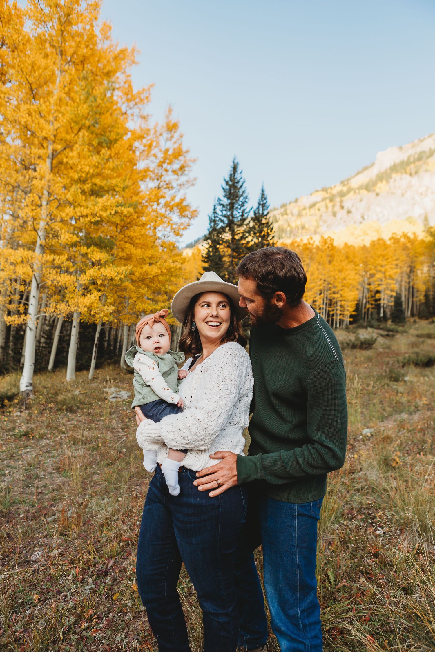 A tender moment captured against a backdrop of golden aspen trees in the mountains.
