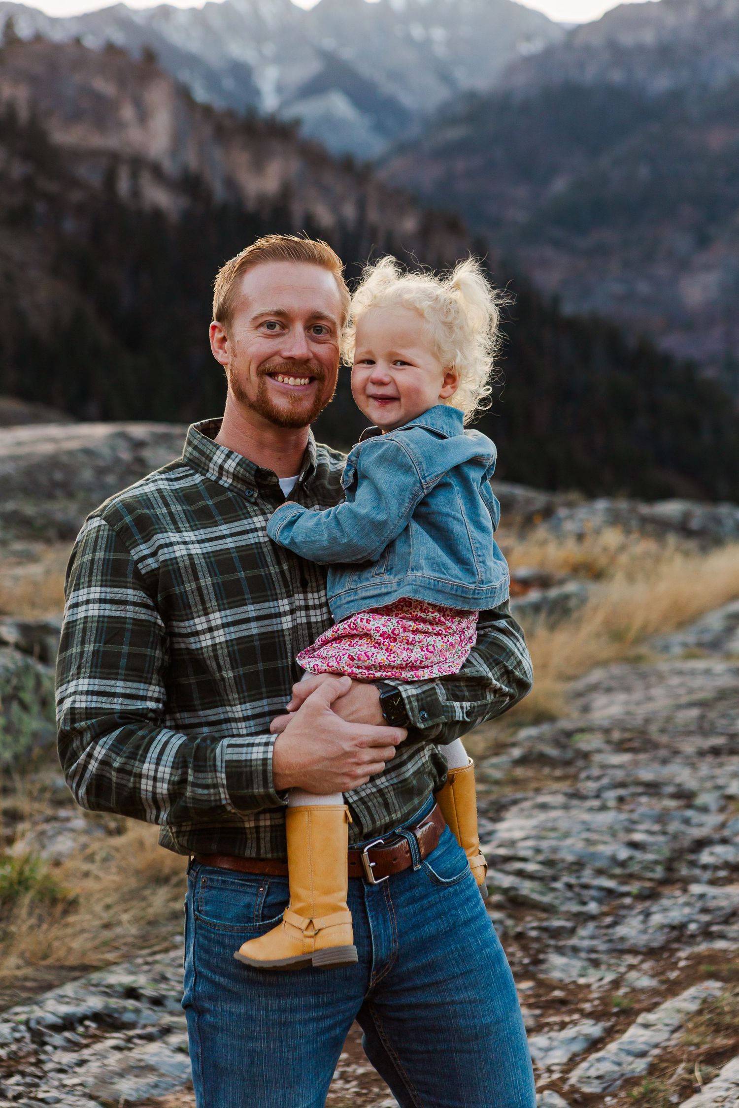 Joyful outdoor portrait with stunning mountain landscape and fall colors in background.