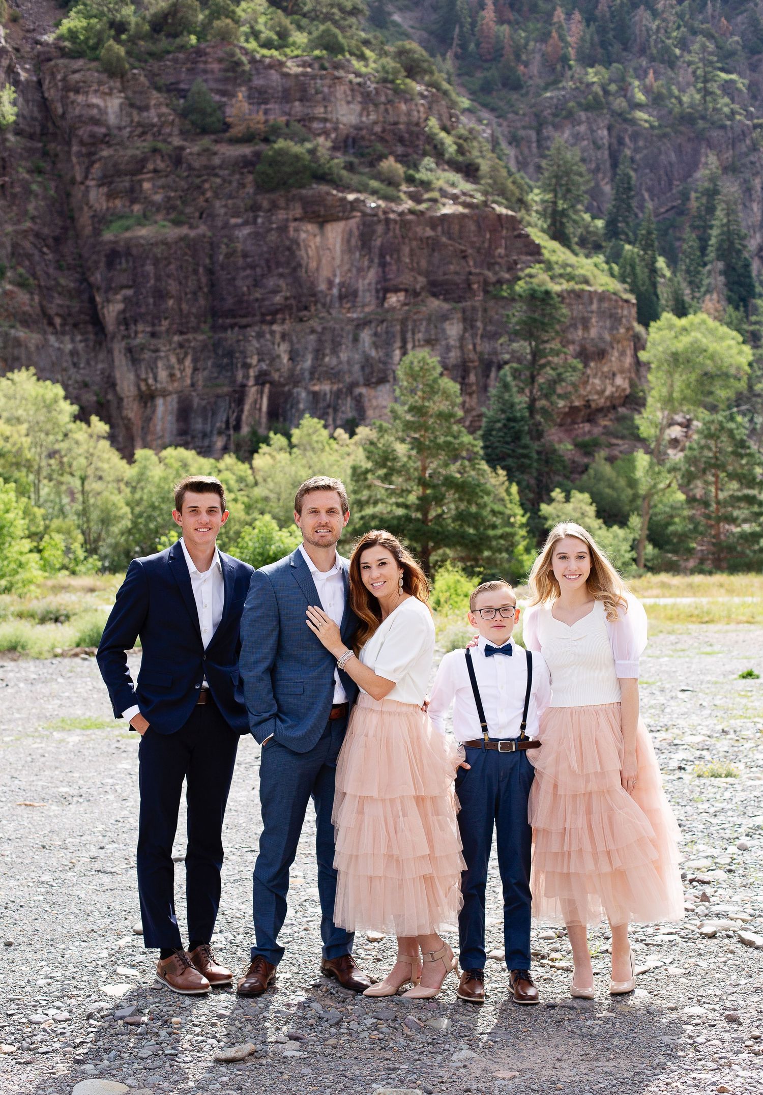 Family portrait with matching outfits in front of a majestic canyon wall.
