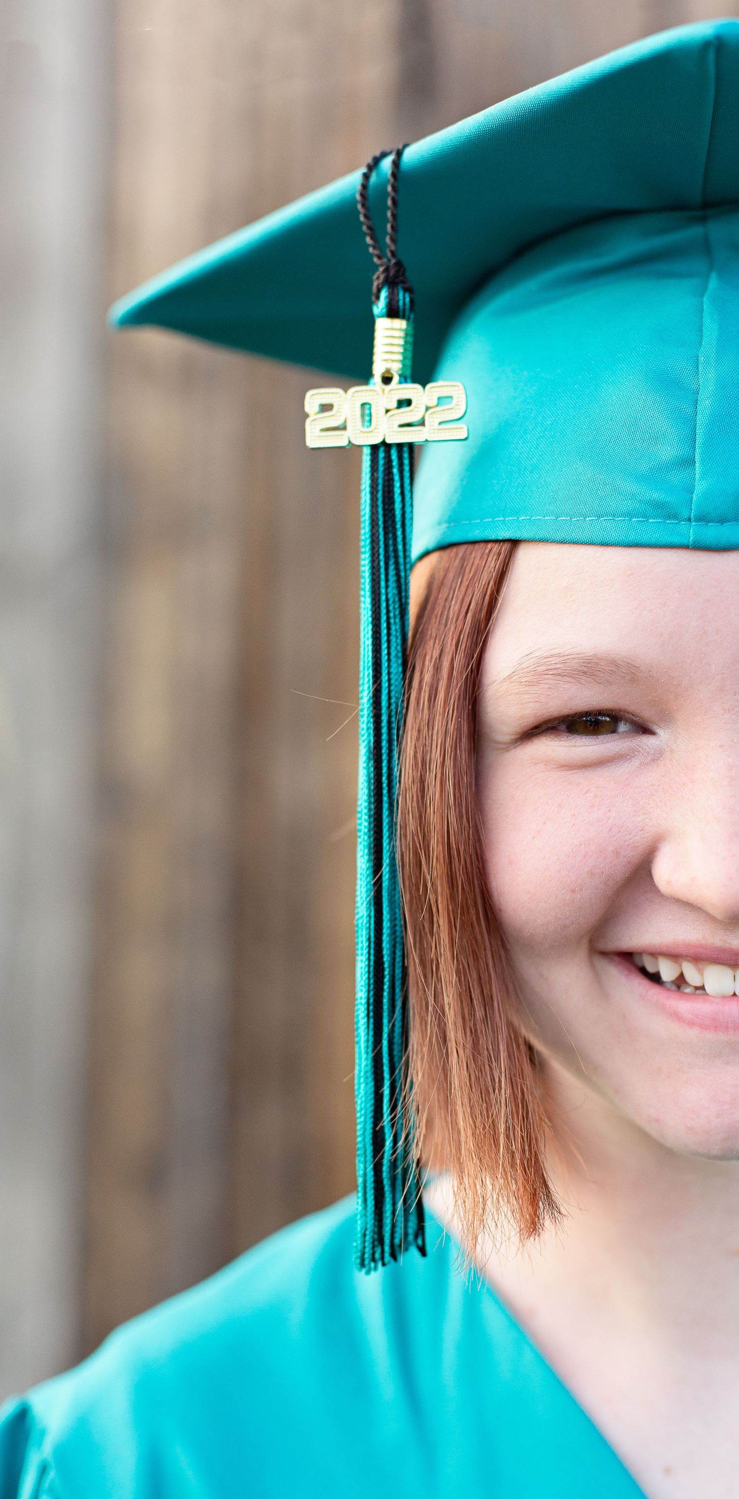 A close-up of a 2022 graduation cap tassel in teal green.