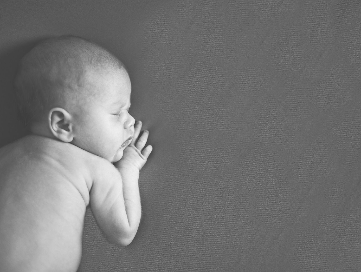 Black and white portrait of sleeping baby in peaceful side pose.