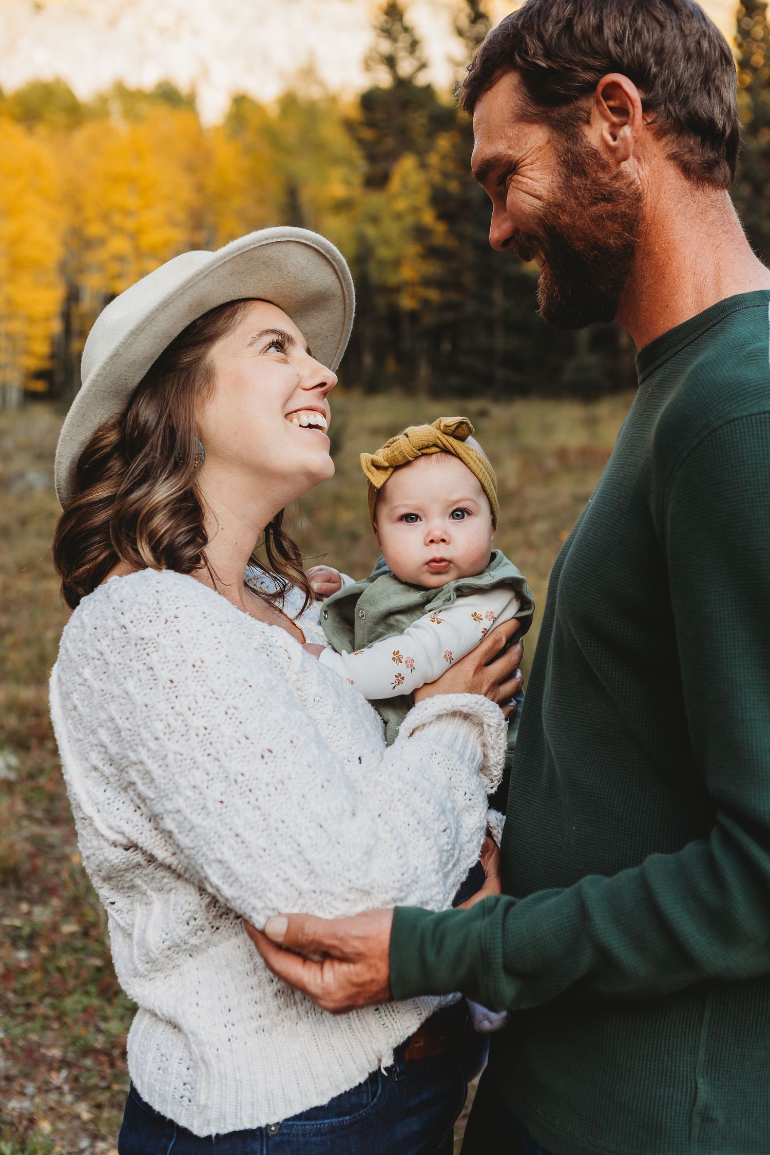 Loving family embrace against backdrop of golden autumn aspens.