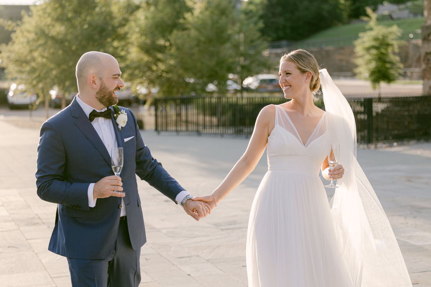 Wedding couple celebrates with champagne outdoors during their special day.
