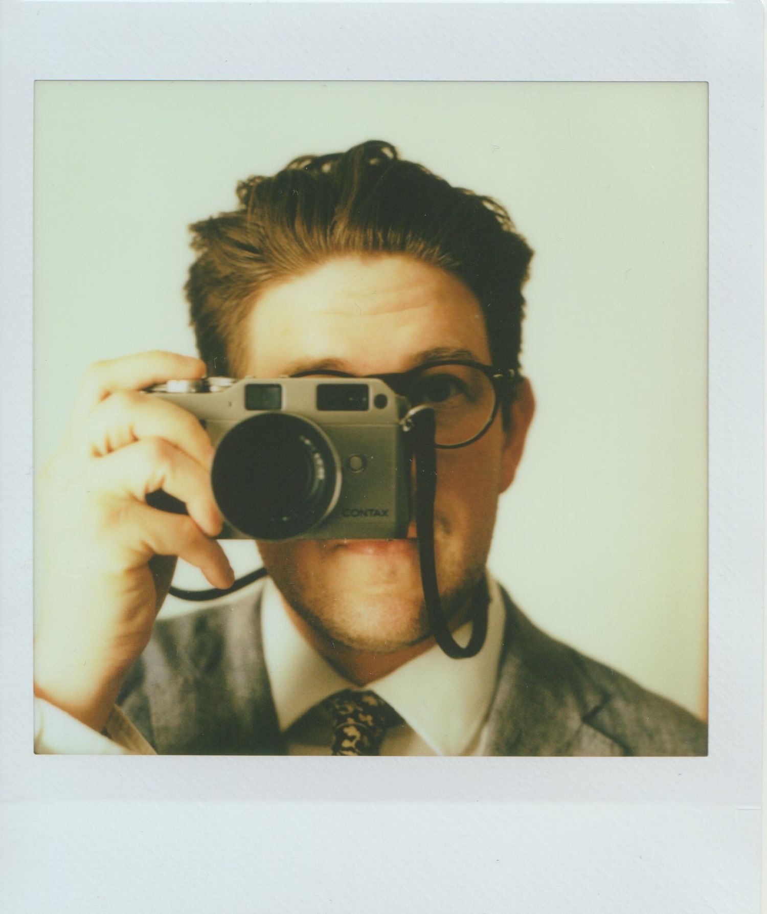 Series of vintage-style polaroid photos showing someone looking through a camera lens with dramatic lighting.