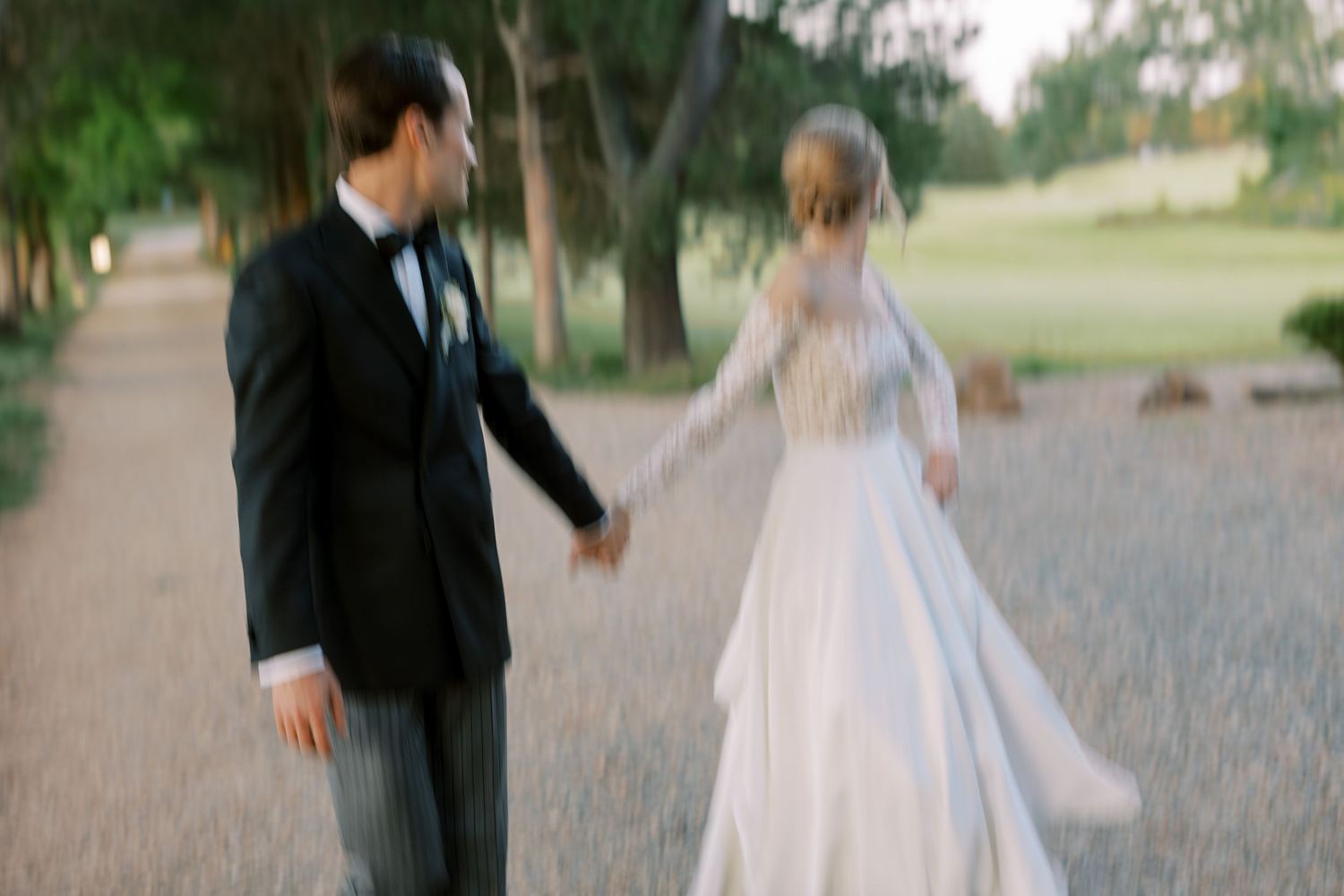 A couple strolls together along a scenic path during their wedding photoshoot.
