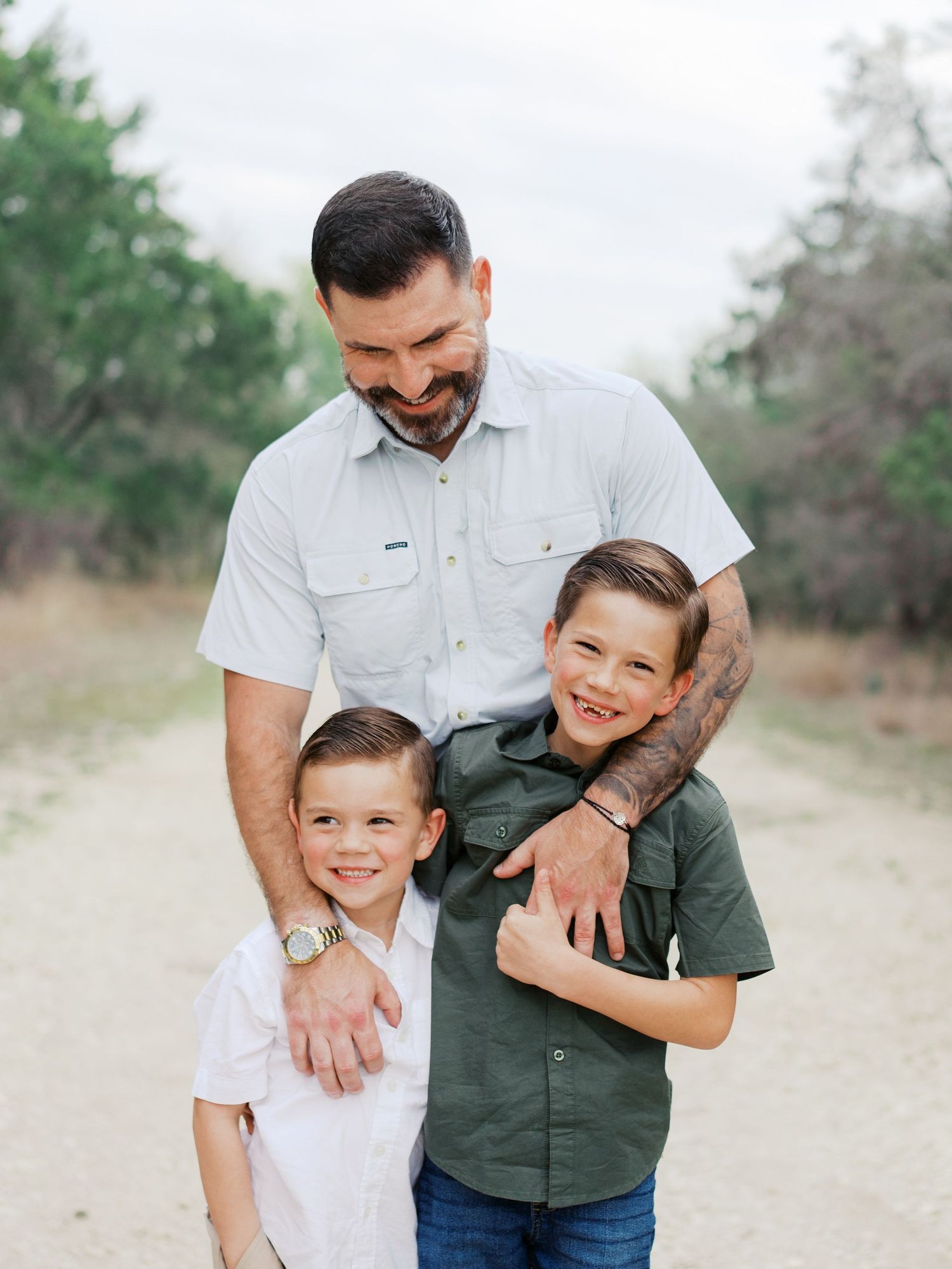 Father hugging his children during an outdoor family photography session in San Antonio, Texas