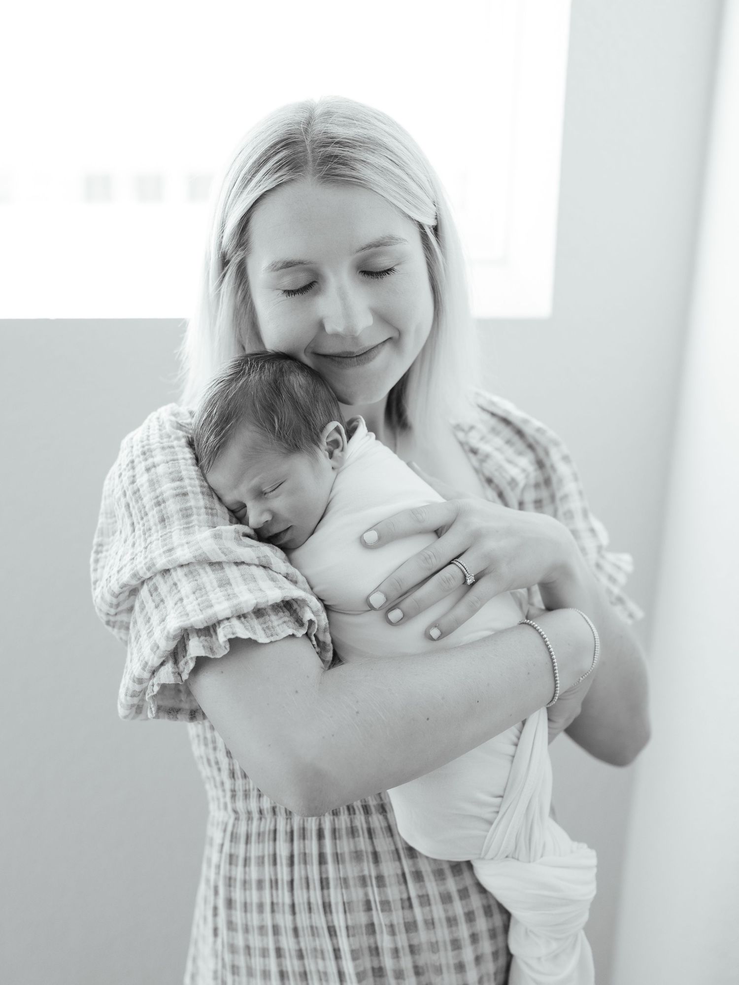 Mother hugging her newborn baby boy during an in home session in Dripping Springs, Texas