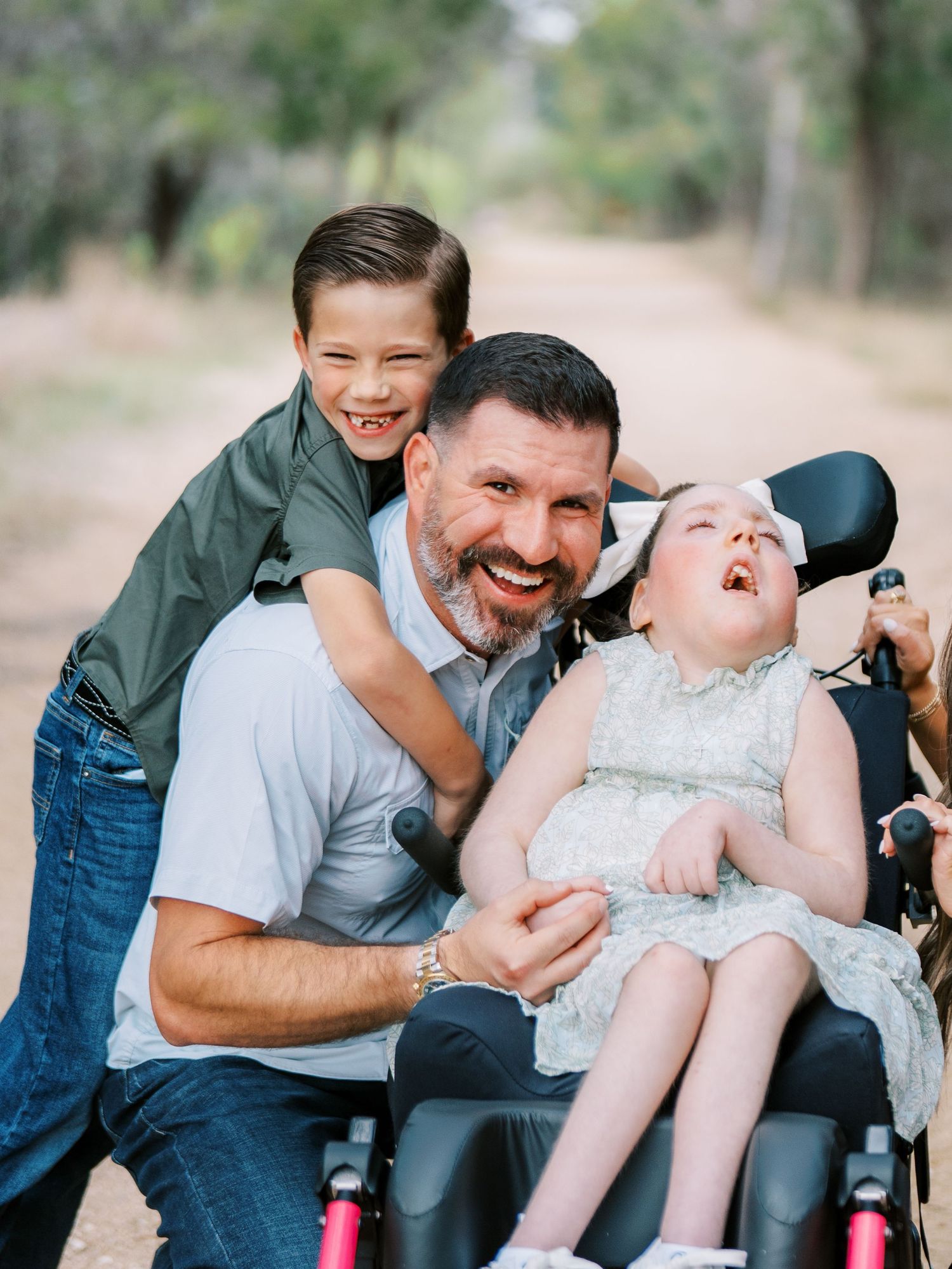 Father laughing with his children during a playful outdoor family photography session