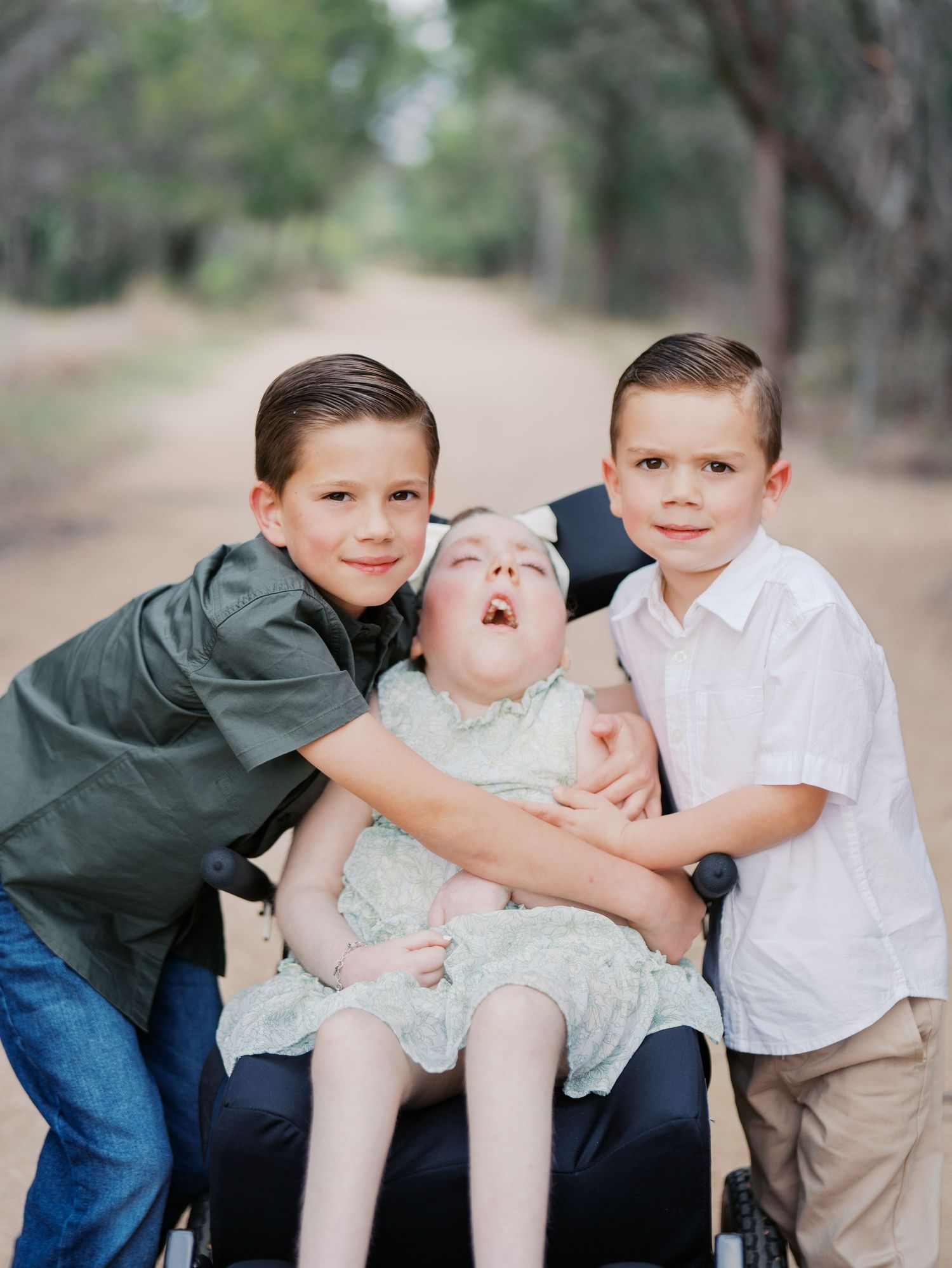 Three siblings smiling together during an outdoor family photography session