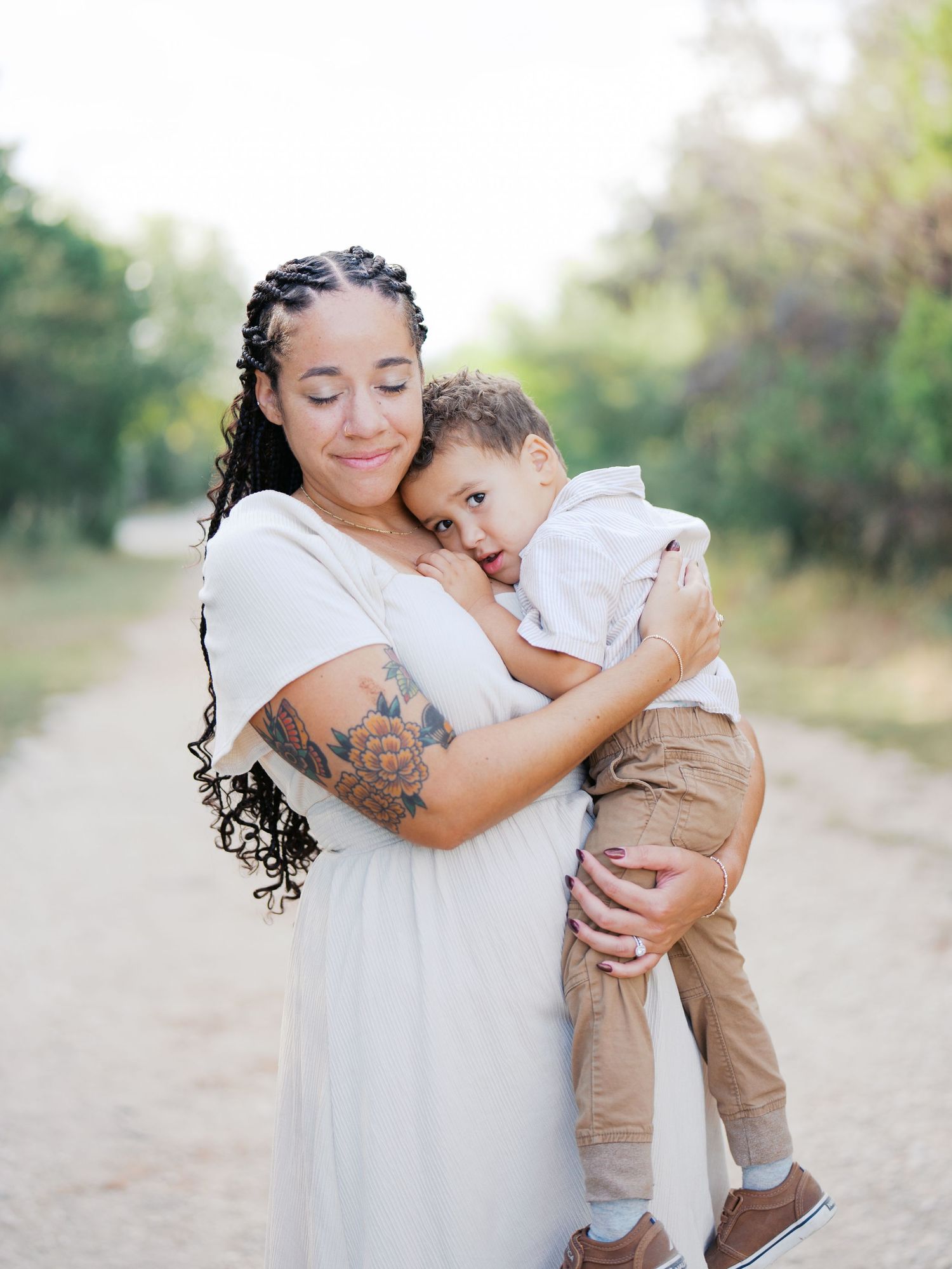 Mom snuggling with her toddler outdoors for a family photo session in San Antonio, Texas