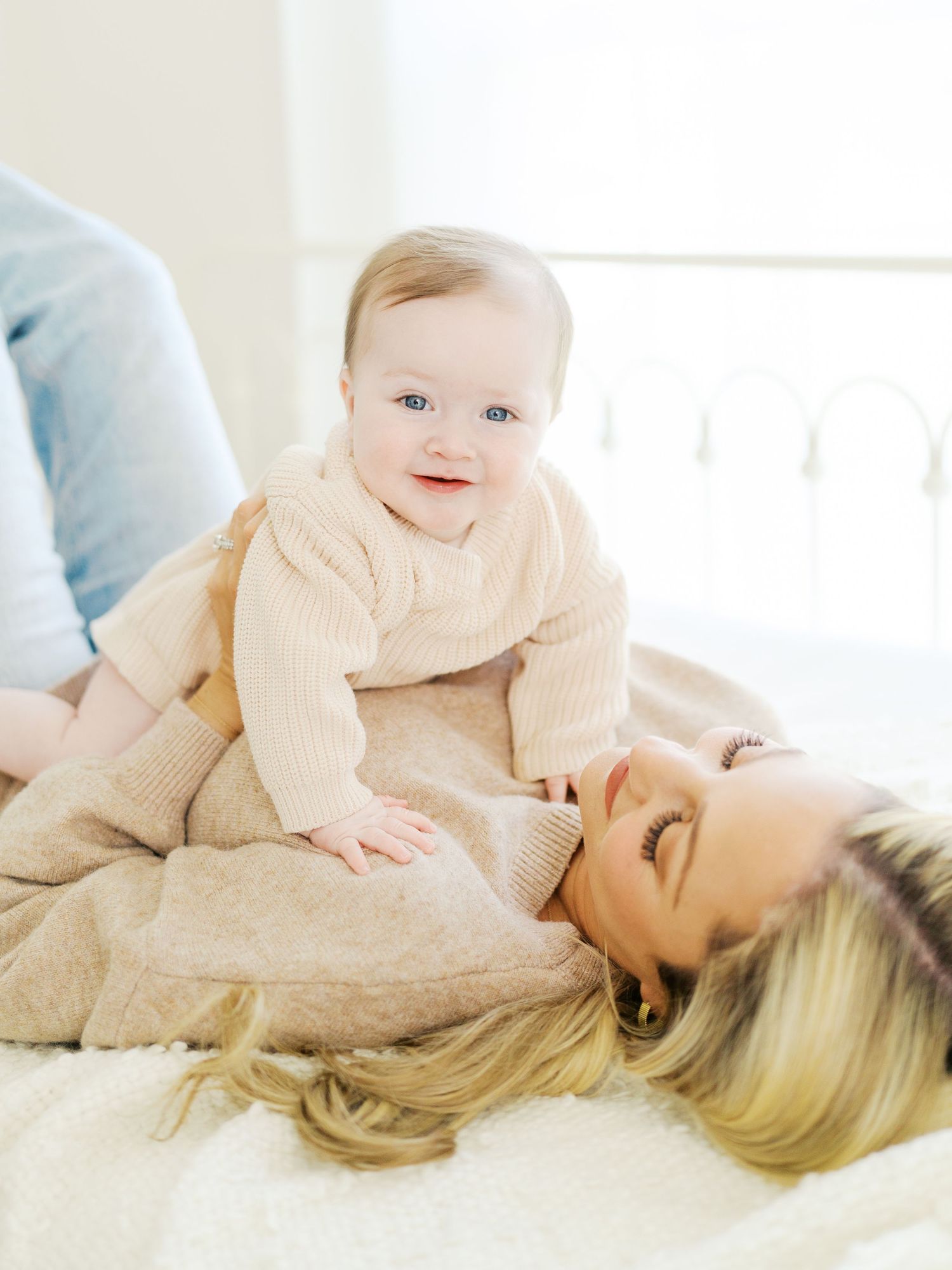 Mom joyfully carrying her baby in a studio session .