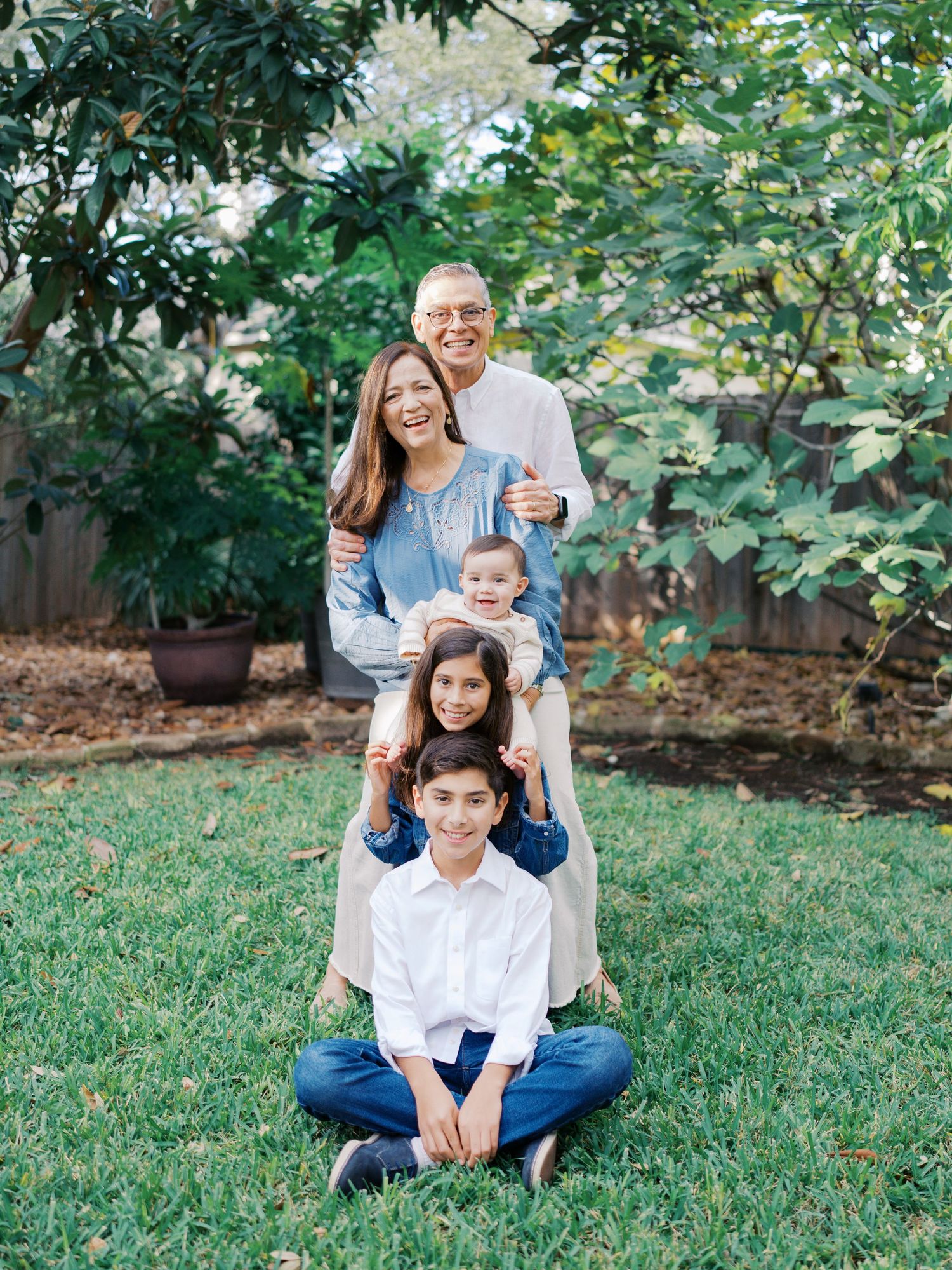 Grandparents taking pictures with their grandchildresn outdoors during an extended family session in San Antonio, Texas.